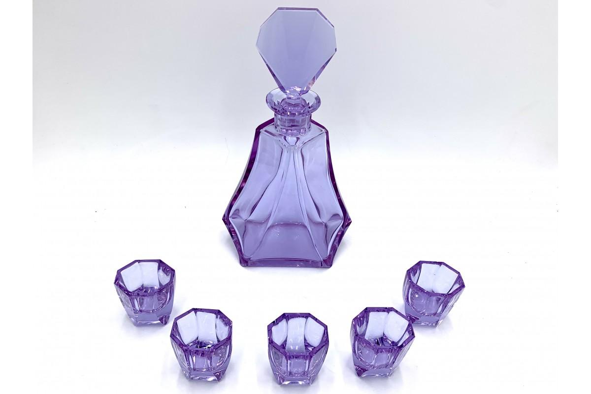 A liqueur set which includes a decanter with a stopper and five octagonal glasses.

The unique set is made of alexandrite glass, which changes its color depending on the light from violet to blue. Made in the Czech Republic in the 1930s.

Very