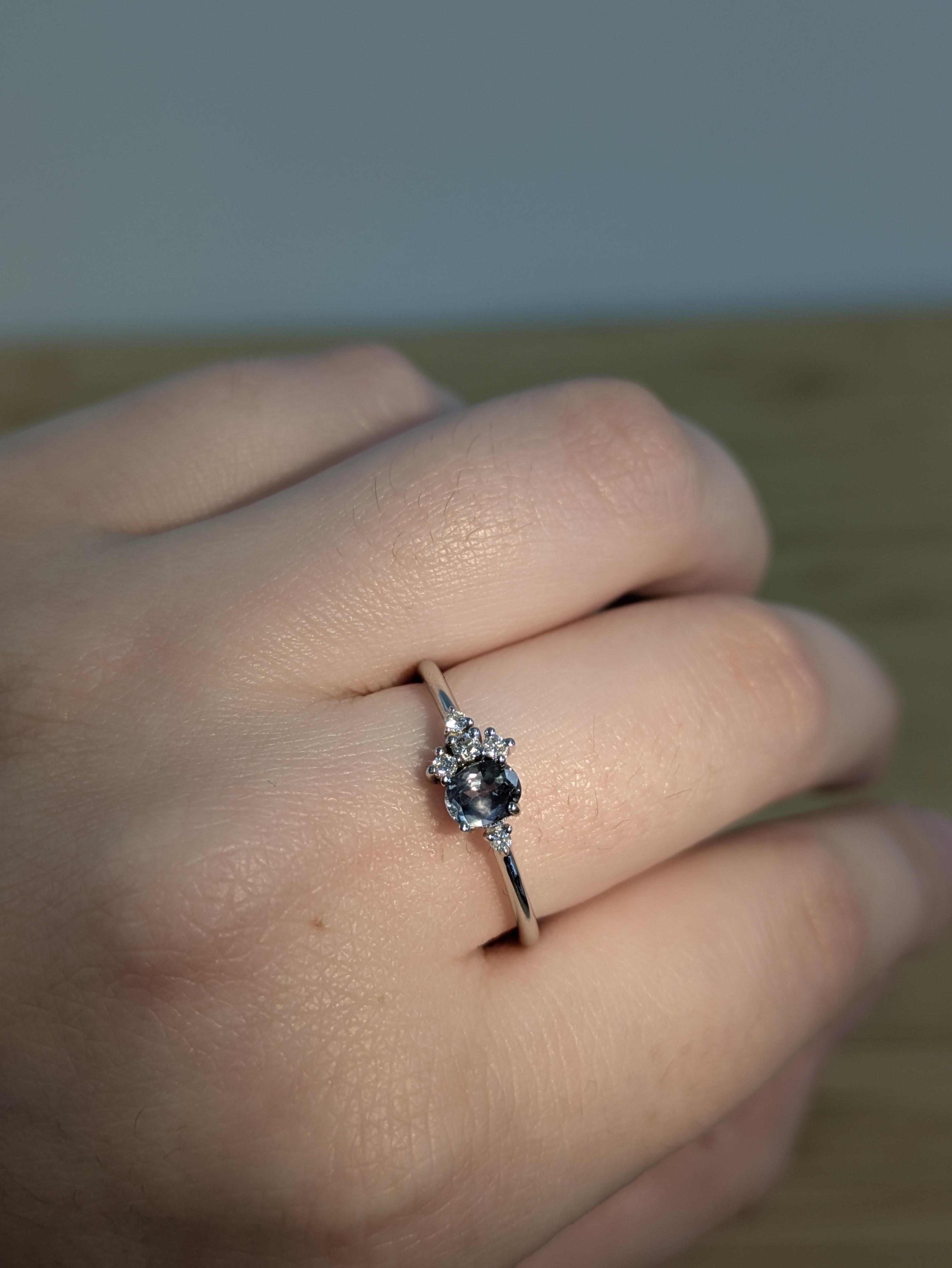 Incastonato in oro bianco massiccio 14k, questo affascinante anello presenta un'alessandrite rotonda che passa dal verde al rosso sotto una luce diversa, accentuata da diamanti naturali per una maggiore brillantezza. Un pezzo raro e ipnotico che