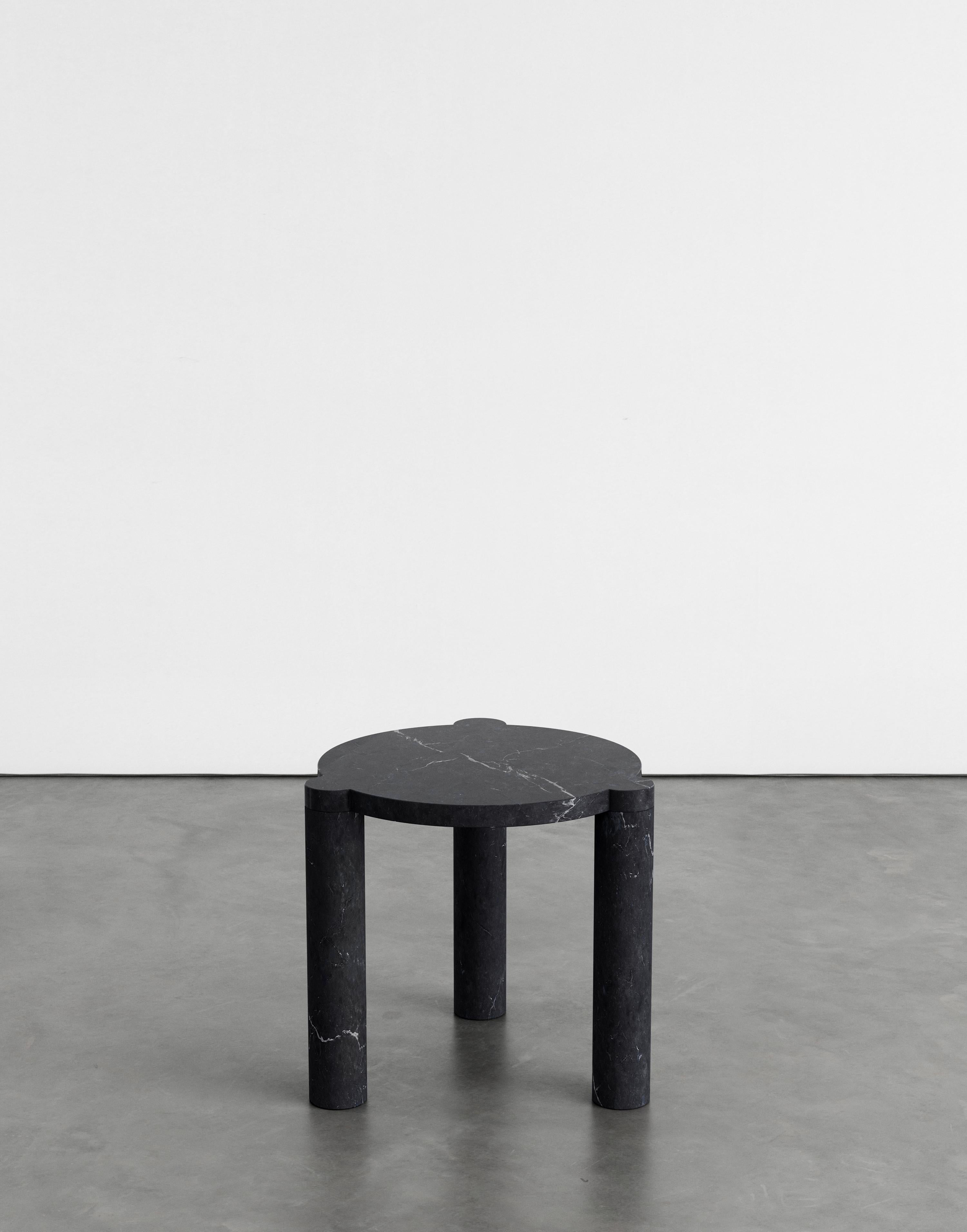 Alexis 45 side table by Agglomerati
Dimensions: D 45 x H 45 cm.
Materials: Nero Marquina marble.
Available in other stones. 

Alexis coffee table has off-set, cylindrical legs that curve flush underneath the tabletop, providing a soft release and