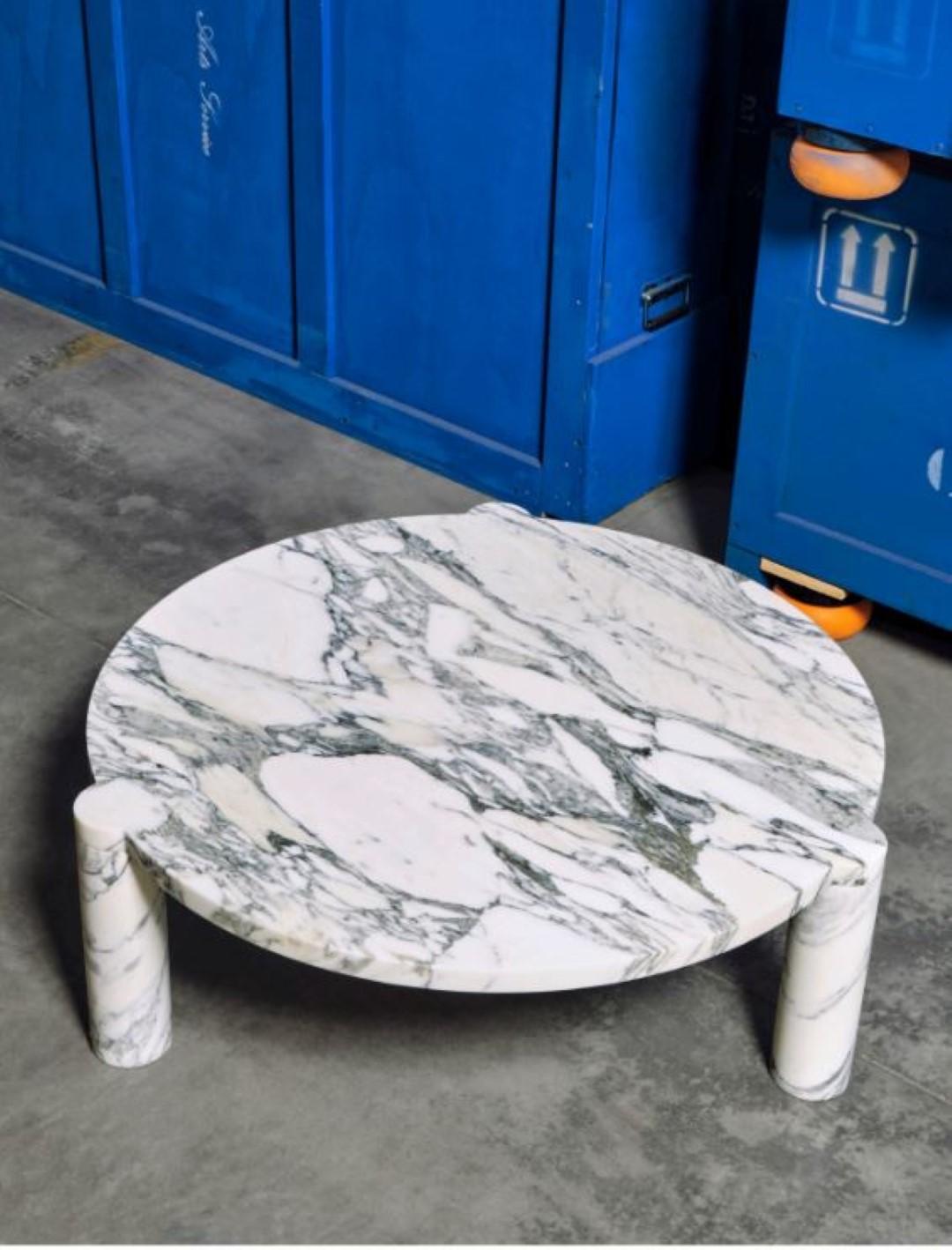 Alexis 90 Coffee table by Agglomerati
Dimensions: Ø 90 x H 33 cm.
Materials: Arabescato Marble.
Available in other stones. 

Alexis Coffee Table has off-set, cylindrical legs that curve flush underneath the tabletop, providing a soft release and