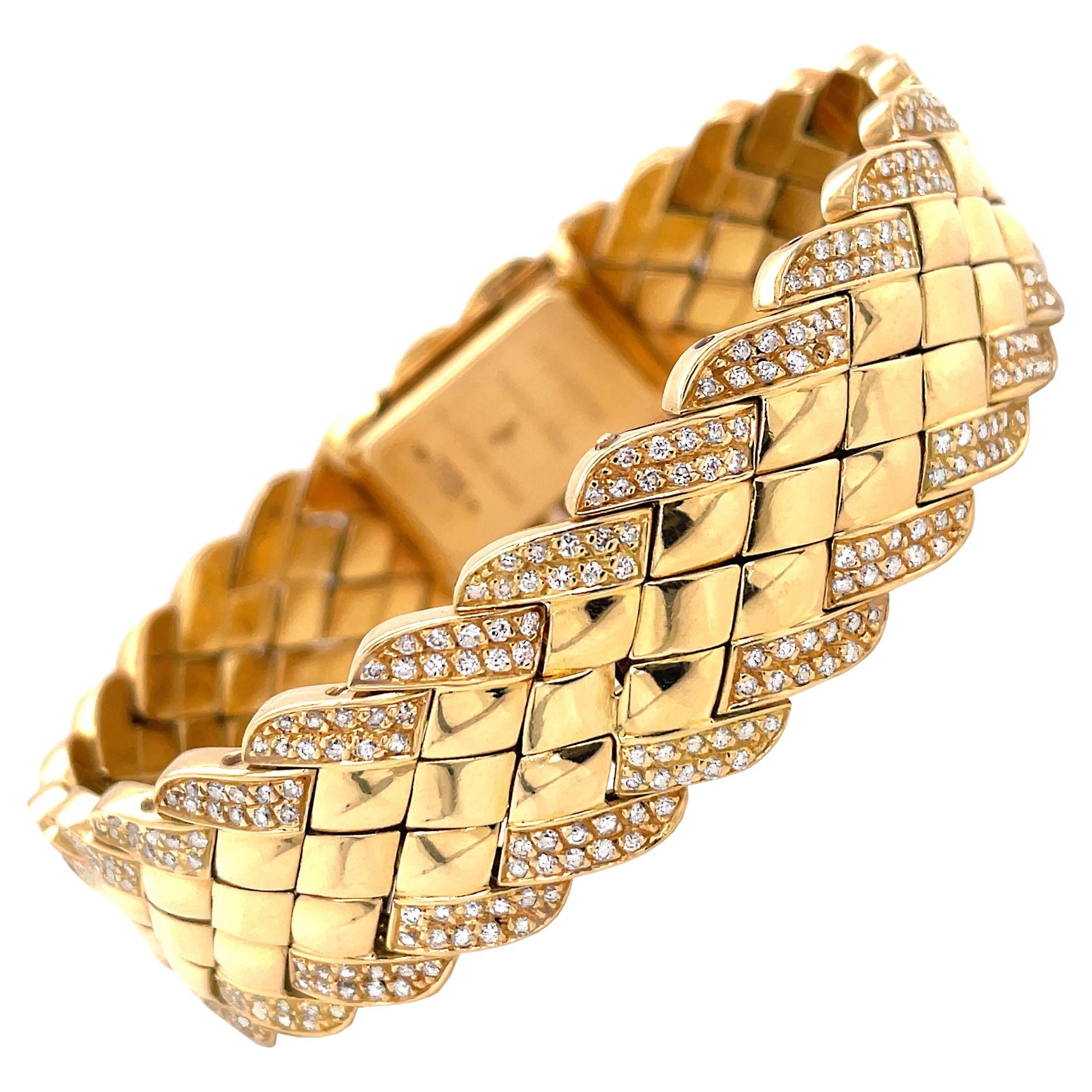 This gorgeous bracelet watch made by French jewellery designer, Alexis Barthelay is made in 18 carat yellow gold. The bracelet is beautifully crafted with diamond shaped metal panels, finished with a diamond set boarder inlaid with approximately