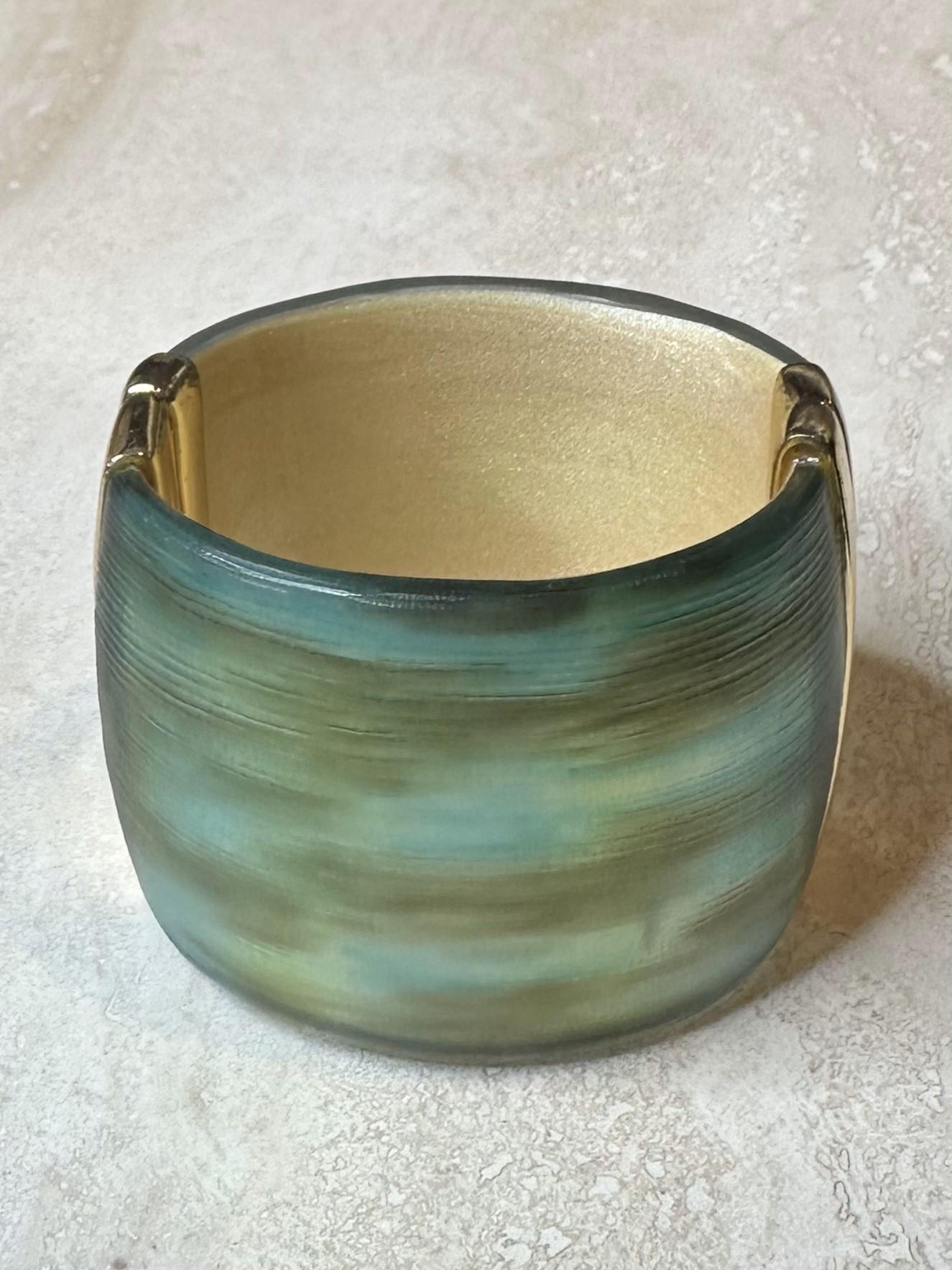 The Alexis Bittar Gold & Blue Cuff is a luxurious, high-fashion accessory that combines bold gold with striking blue, creating a sophisticated and eye-catching statement piece. Its sculptural design and artistic craftsmanship make it ideal for both