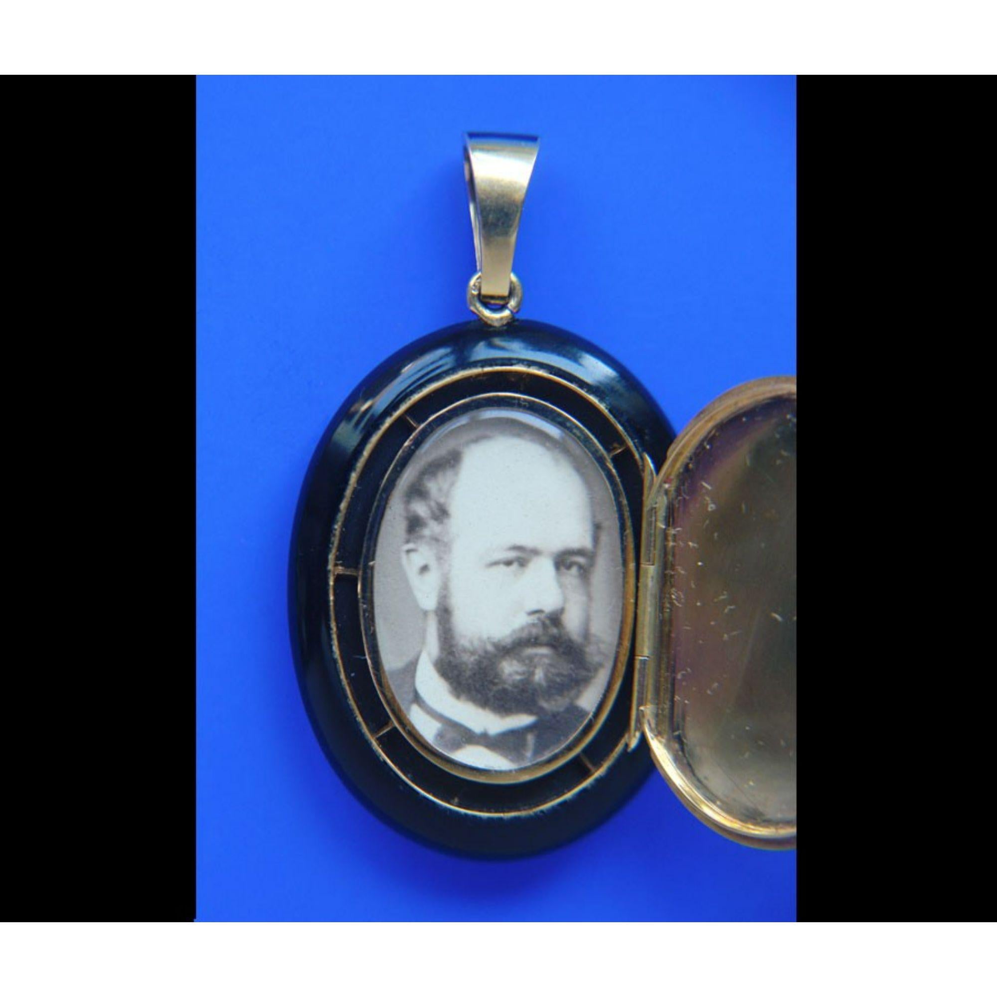 Un medaglione in oro 18 carati e onice, con le iniziali EF intrecciate.  scritta in diamanti taglio rosa. EF sta per Elisa Falize, moglie di Alexis Falize, a cui apparteneva. All'interno c'è la fotografia di Alexis, circa 1860,