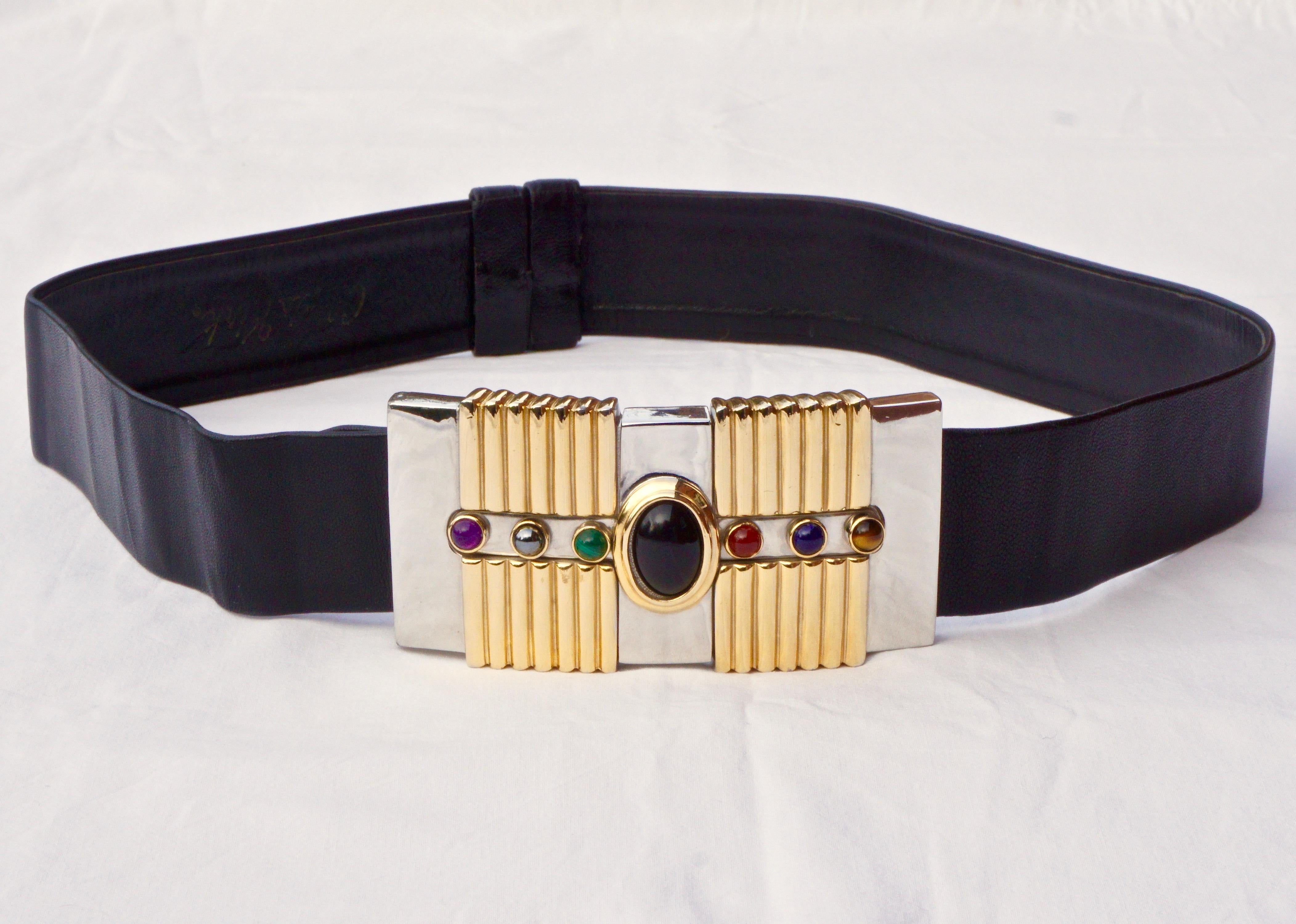 Alexis Kirk black leather belt, featuring a large buckle with a gold plated ridged design, and shiny silver plating set with semi-precious stones. The belt has an adjustable slide design, and is maximum length 96cm / 37.79 inches by width 4.8cm /