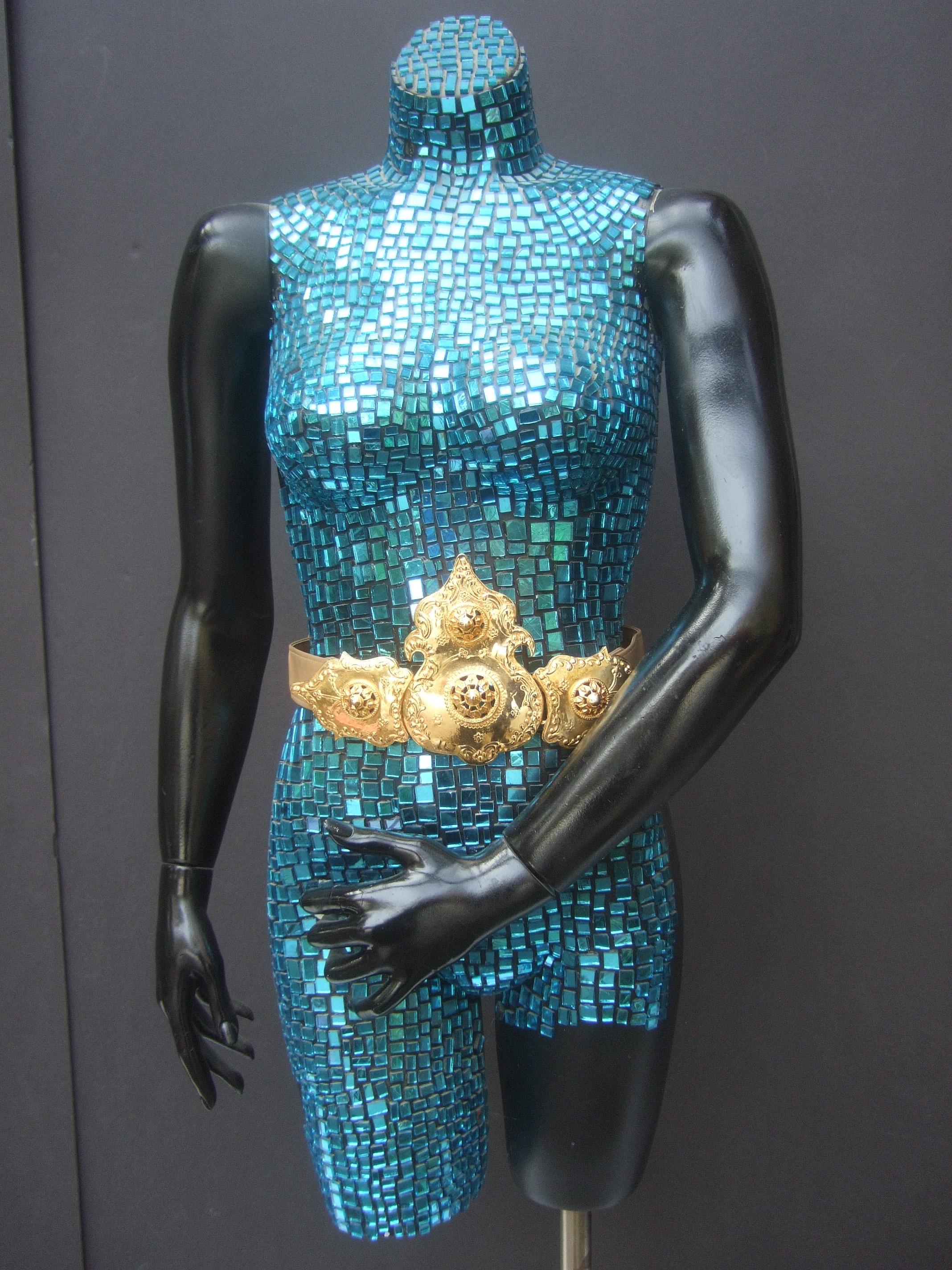 Alexis Kirk Cinturón con hebilla de oro etrusco c 1980s
La increíble hebilla de metal dorado a gran escala está diseñada con volutas 
y am designs impresionados.

La hebilla de gran tamaño está diseñada en tres secciones. Emparejado con un
cinturón