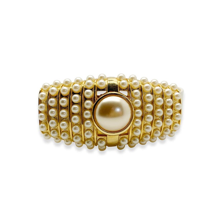 A stunning Alexis Kirk Pearl Buckle Belt. Featuring a large and lustrous gold-plated buckles set with more than eighty glass whole faux pearls.   

Vintage Condition: Very good without damage or noteworthy wear. 
Materials: Gold plated metal, glass