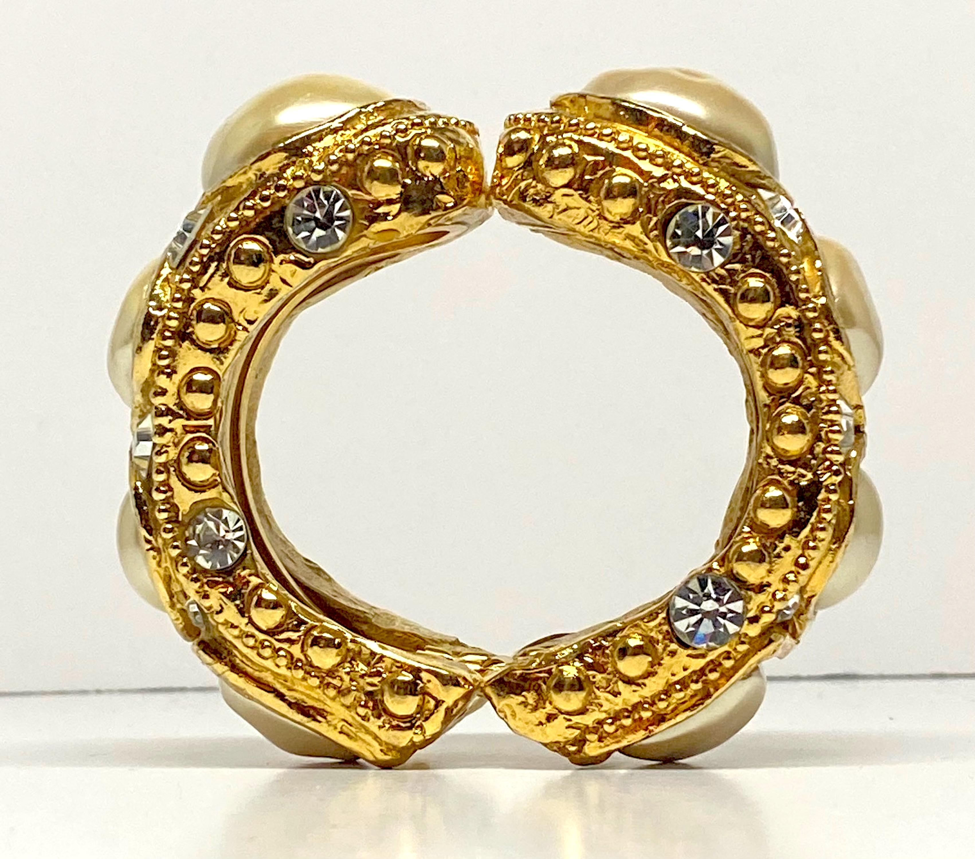An incredible Byzantine style cuff style bracelet by French designer Alexis Lahellec from the later 1980s. The cuff is a clamper style. It has a gold plate metal framework in two pieces hinged together. On each half of the framework a cast and gilt