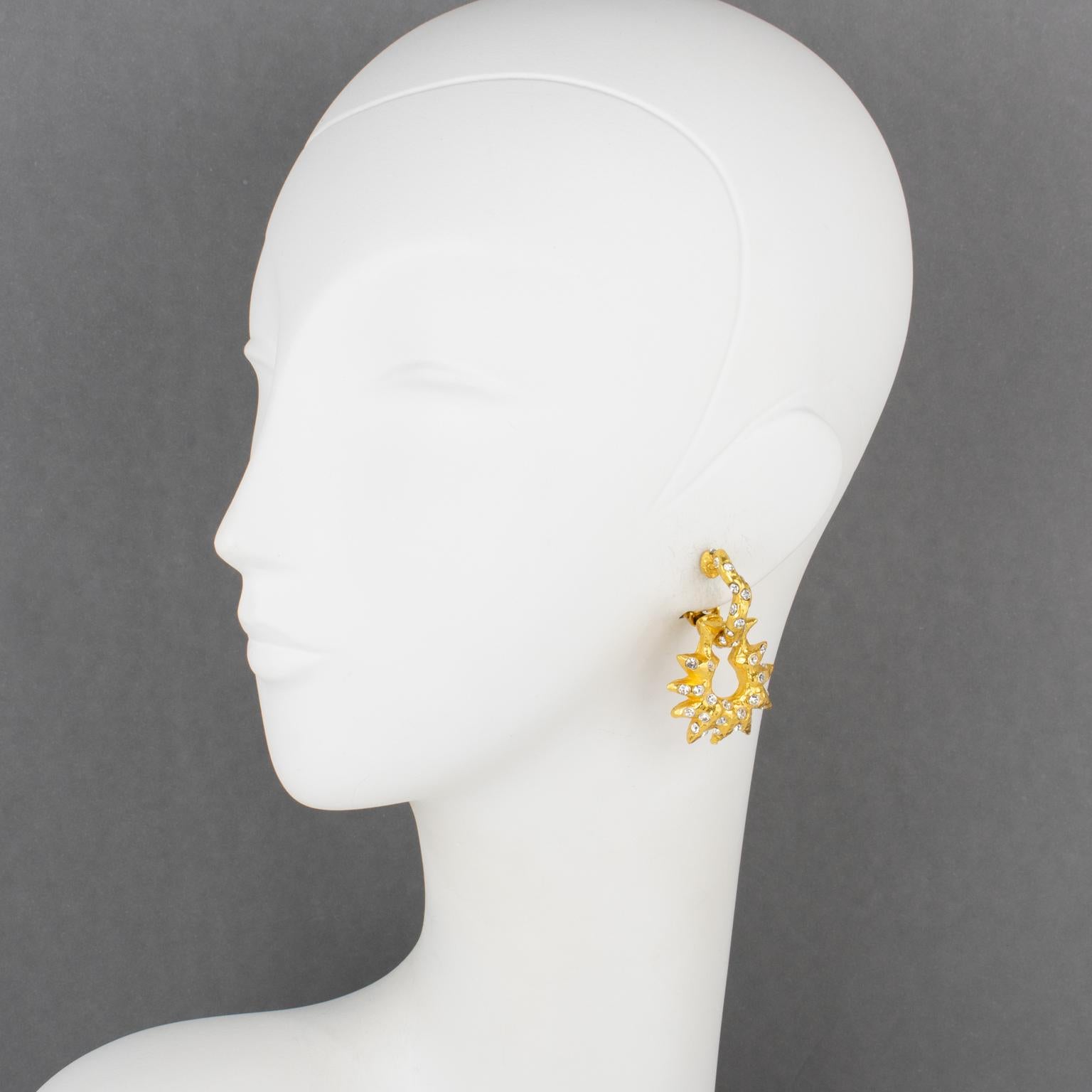 Estos magníficos pendientes de clip del diseñador francés Alexis Lahellec Paris tienen una forma dimensional de aldaba colgante con metal dorado, todo tallado y texturizado, complementado con pequeños brillantes de cristal. Cada pieza está firmada