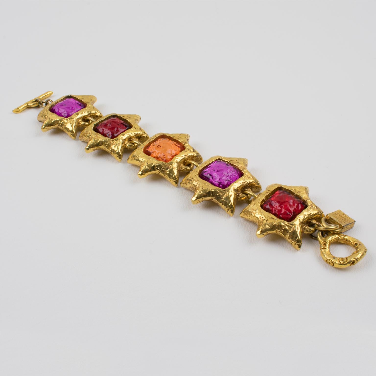 Charming Alexis Lahellec Paris signed link-bracelet. A couture piece from that famous French Jewelry designer, featuring five star-shaped gilt metal-coated resin elements topped with colorful resin cabochons. Assorted tones of ruby red, apricot