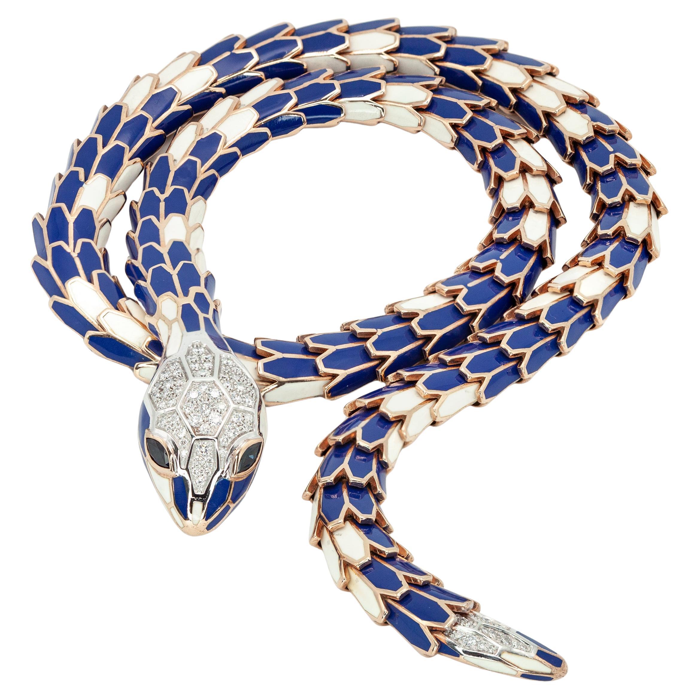 Questa splendida collana di serpenti smaltati è realizzata in oro 18 carati e argento vermeil.
Il corpo del serpente è realizzato in argento finemente dettagliato con una sovrapposizione di smalto blu e bianco, che crea una texture e una lucentezza