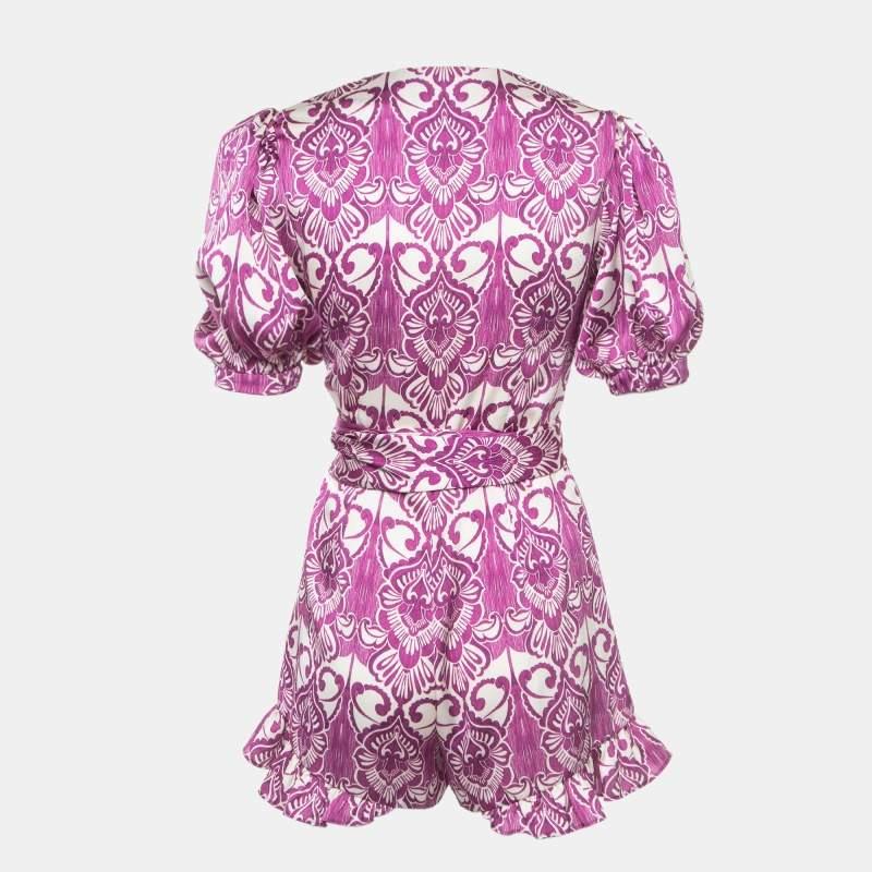 The Alexis romper features a stunning purple print on luxurious satin fabric. This stylish romper boasts a flattering knotted front creating a chic focal point. The lightweight material ensures comfort while the playful design adds a touch of modern
