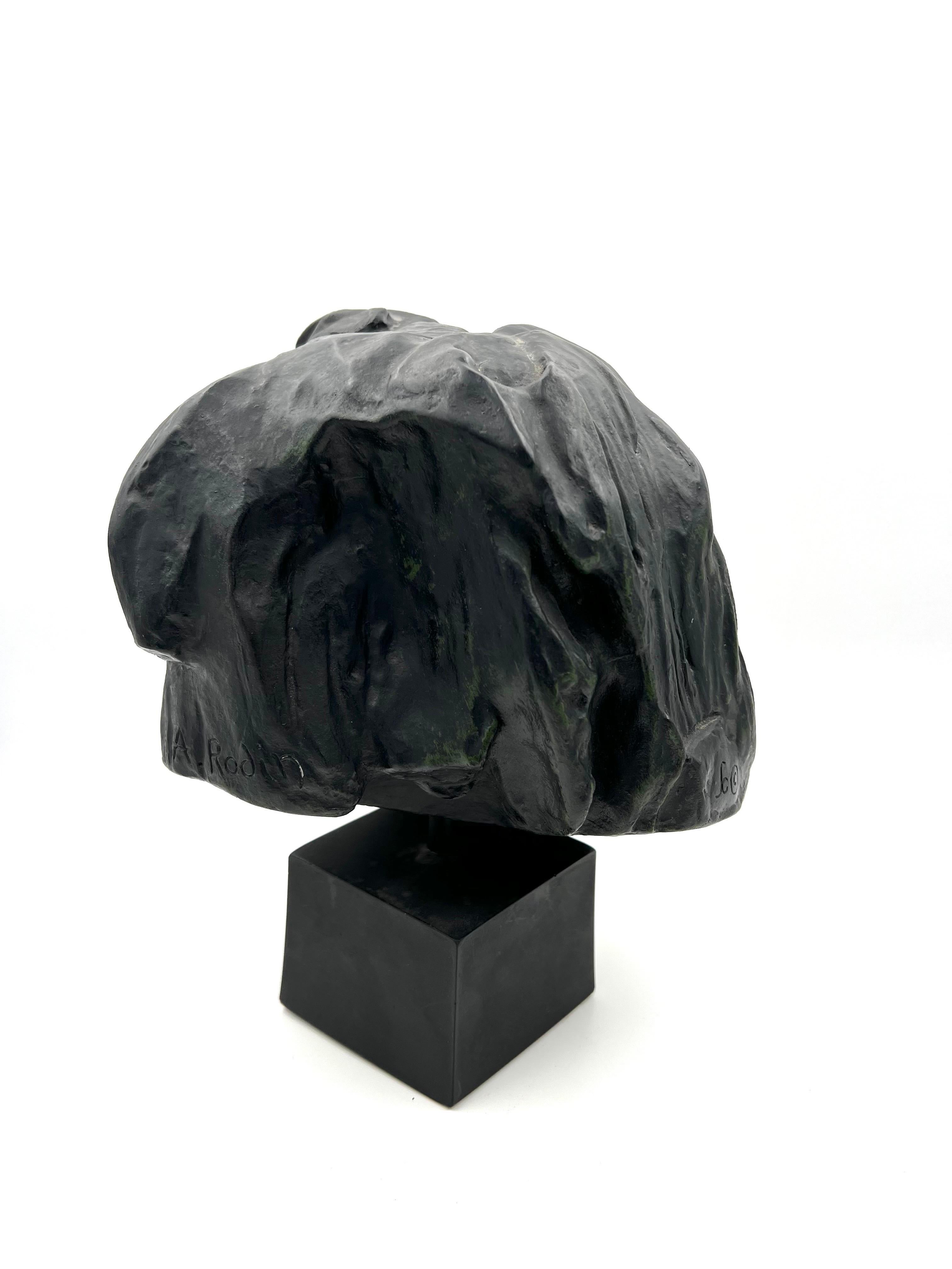 Beautiful reproduction bust after Auguste Rodin in plaster with a verdigris finish and solid black painted wood base.