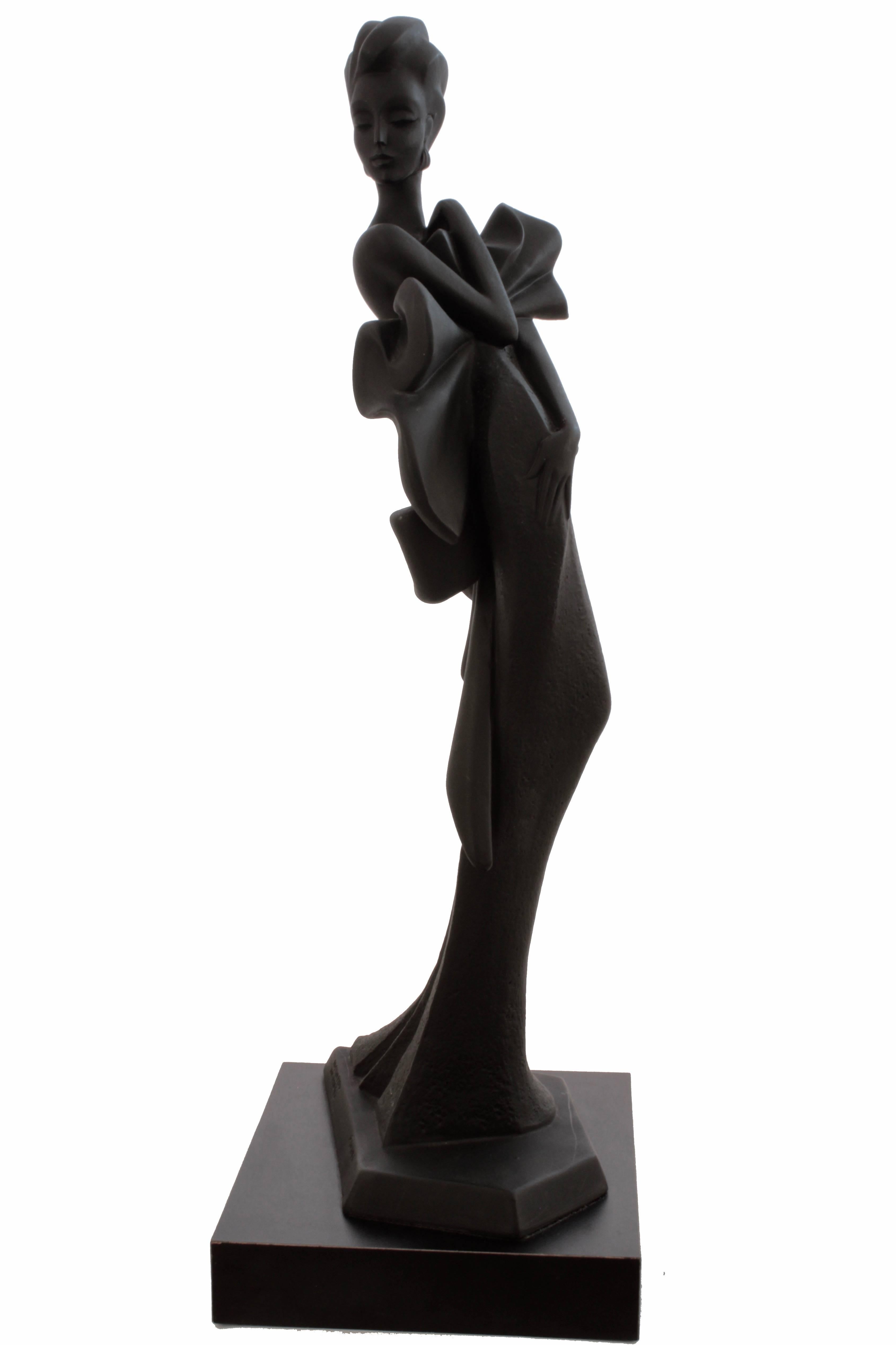 This fabulous 30 inch sculpture of a high fashion woman was produced by Austin Productions and designed by Alexsander Danel in 1990.  From our research, this piece is called ORCHIDE, likely from their high fashion collection. 

The piece stands appx