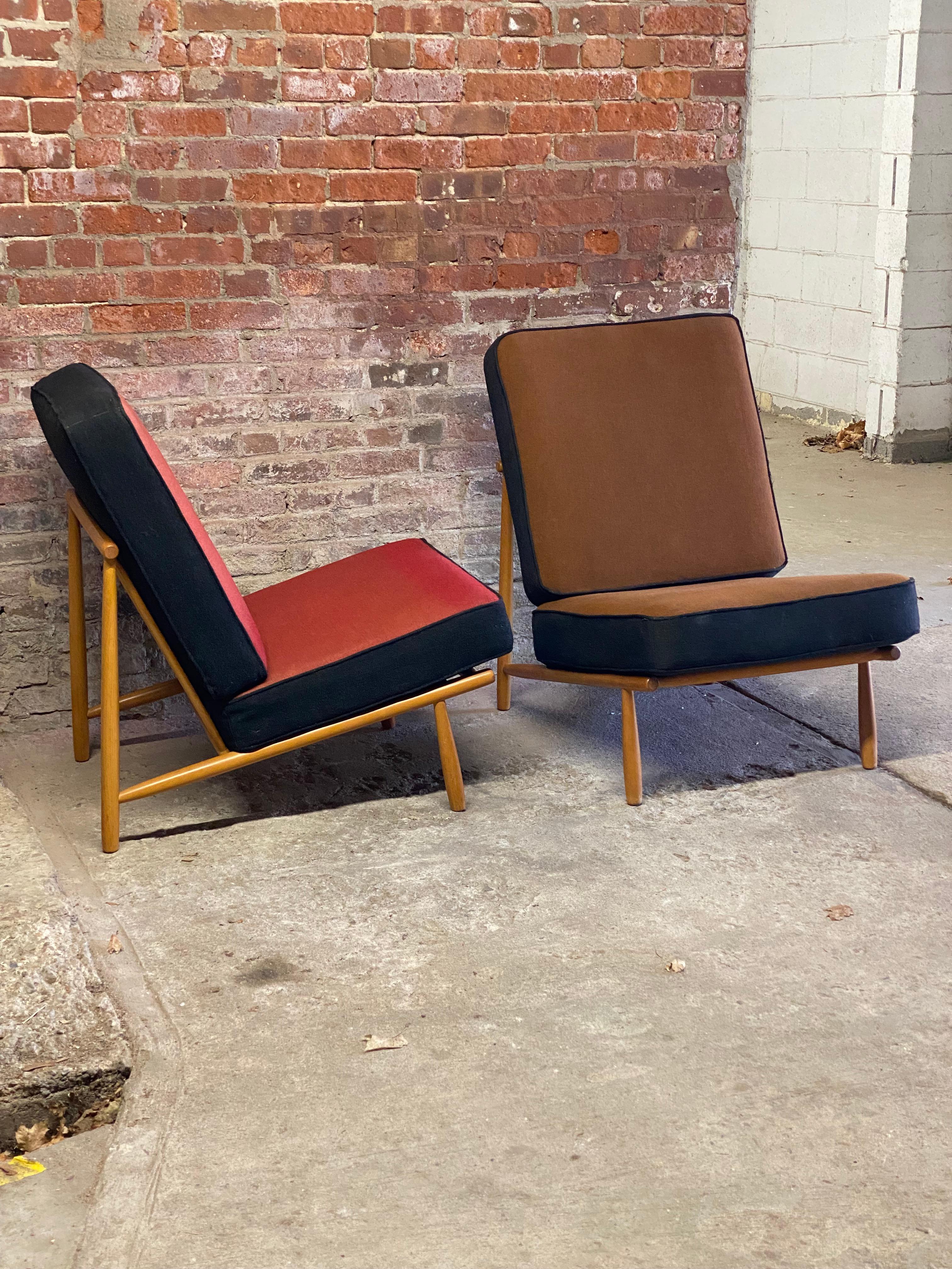 Pair of Alf Svensson for DUX Domus 1 easy chairs. Solid beech dowel legs with spindle backs. Both are signed with DUX metal tag. Beautiful profile. Heavy duty wool fabric cushions in red and brown with black edging. Circa 1960. Good original finish
