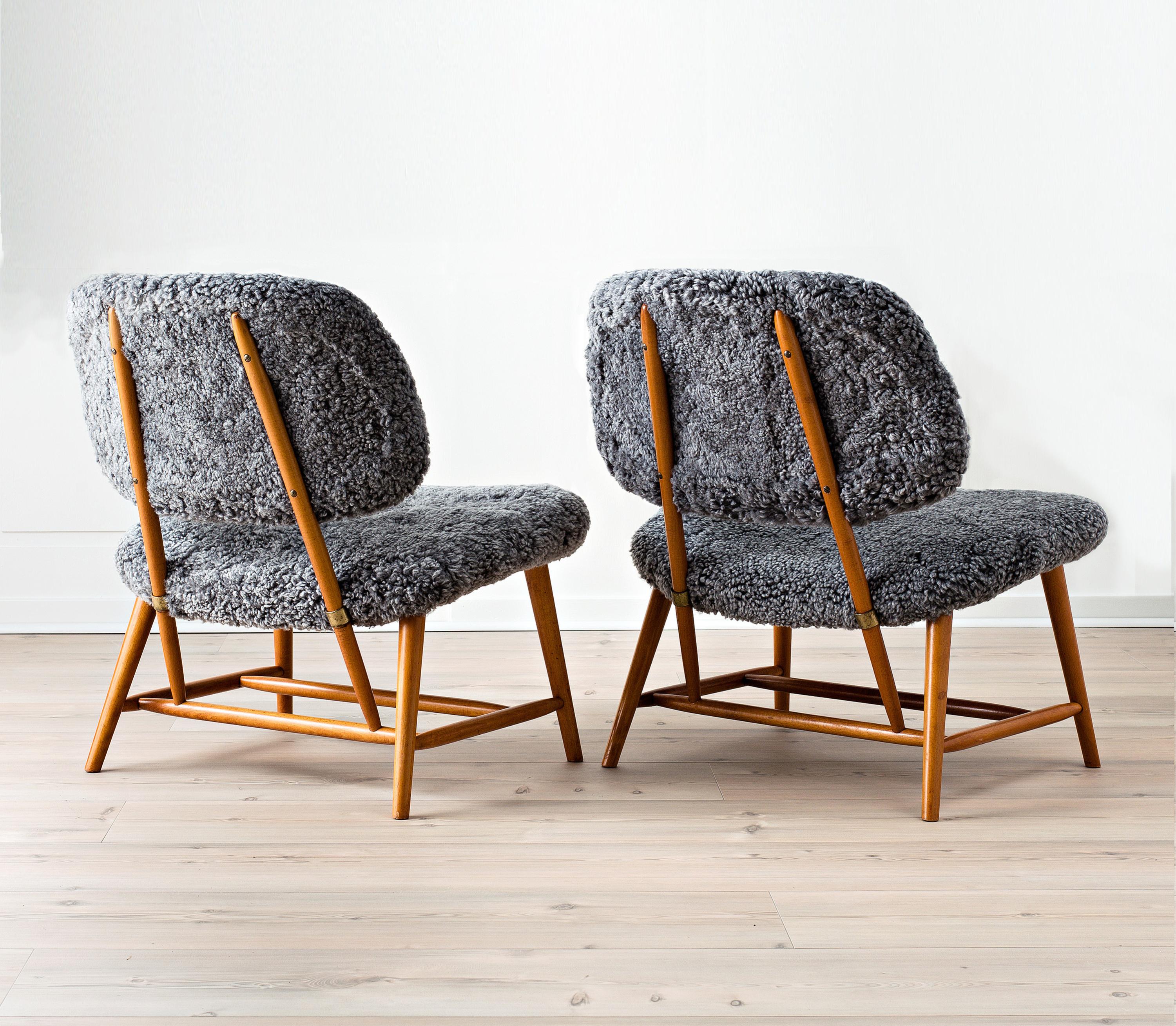 Pair of lounge chair model TeVe designed by Swedish Alf Svensson in 1953 for Ljungs Industrier. Frame in stained beech and brass. Upholstered seat and back with grey toned sheepskin.