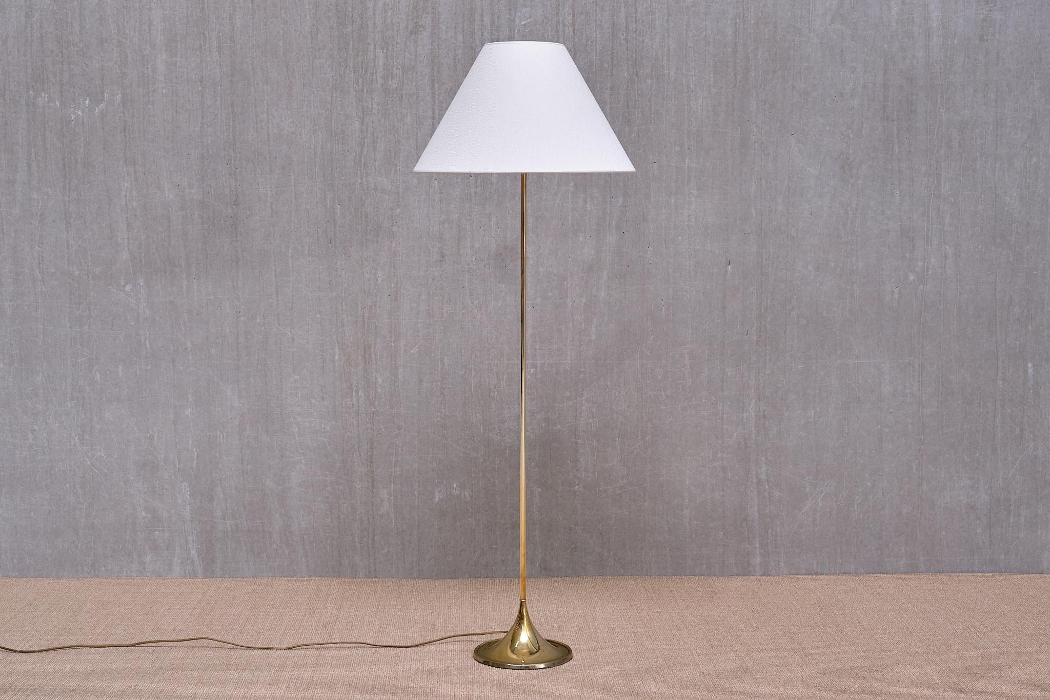 This elegant floor lamp was designed by Alf Svensson and Yngve Sandström in the 1960s. This model numbered G-025 was produced by the renowned Swedish lighting manufacturer Bergboms.

The design features a thin brass stem mounted on top of a round,