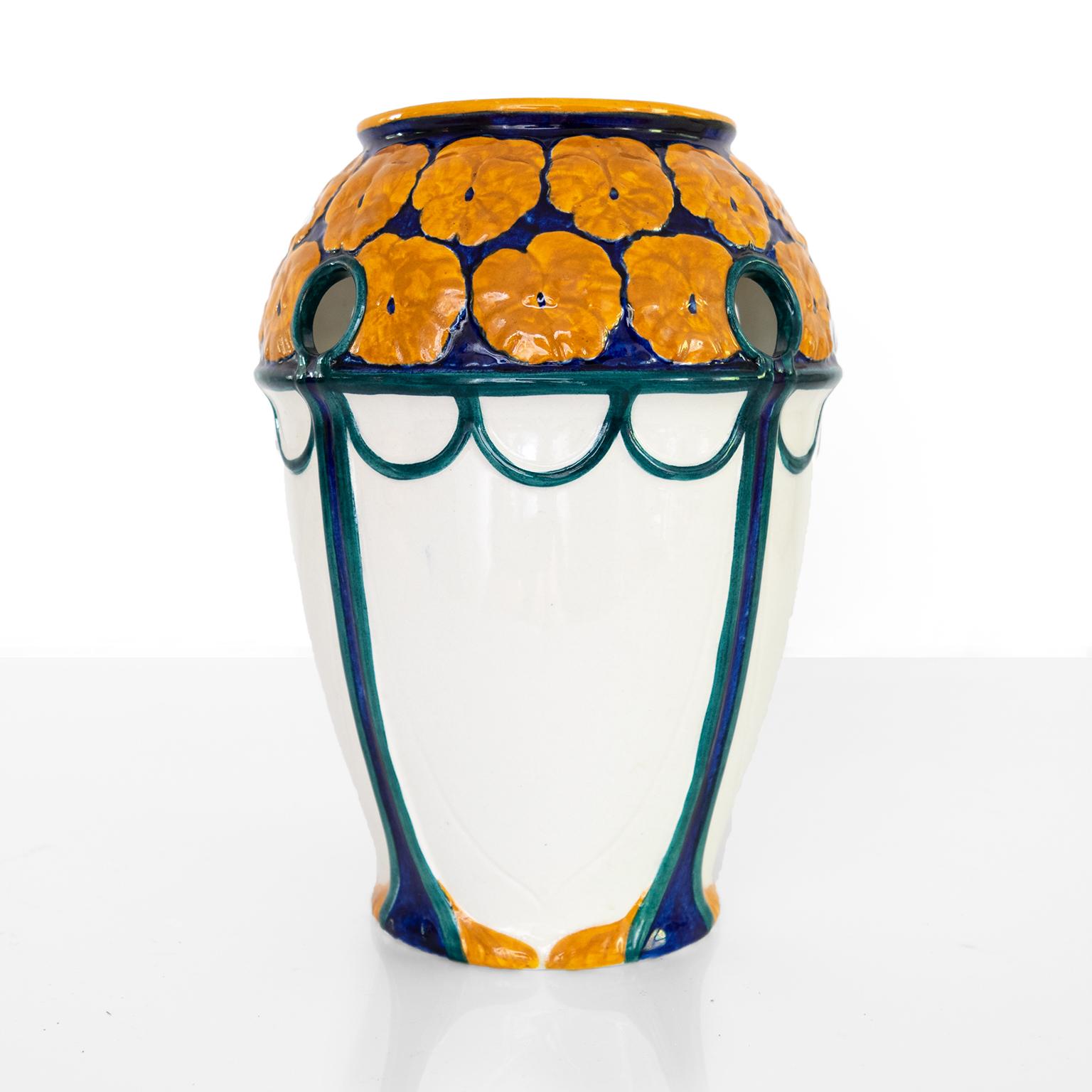 Swedish Art Nouveau period vase with a crown of orange flowers on a deep blue ground. The vase has small round openings along the top. Designed by Alf Wallander and made by Rorstrand, circa 1910. 

Measure: Height: 10.75”.