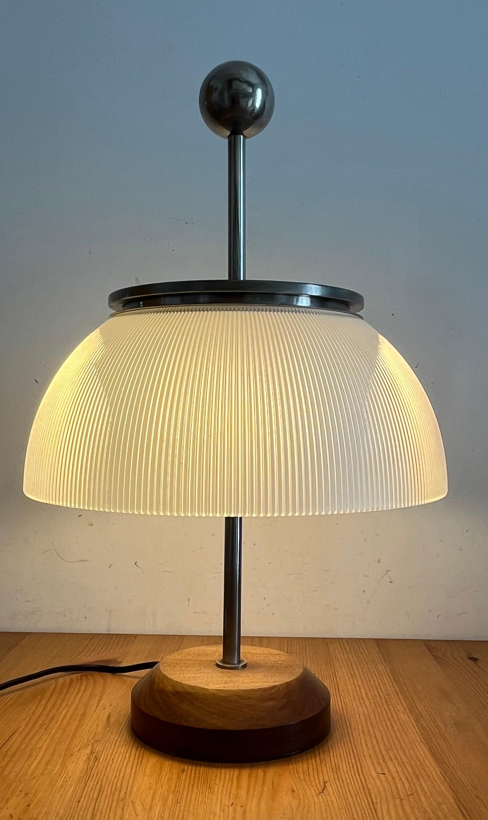 The Alfa table lamp is a lamp that appears in stark contrast to the cold rationalist design in vogue in the 60s. It is a 1959 project by designer Sergio Mazza, which takes up the traditional typology of the abate-jour, using the worked crystal to