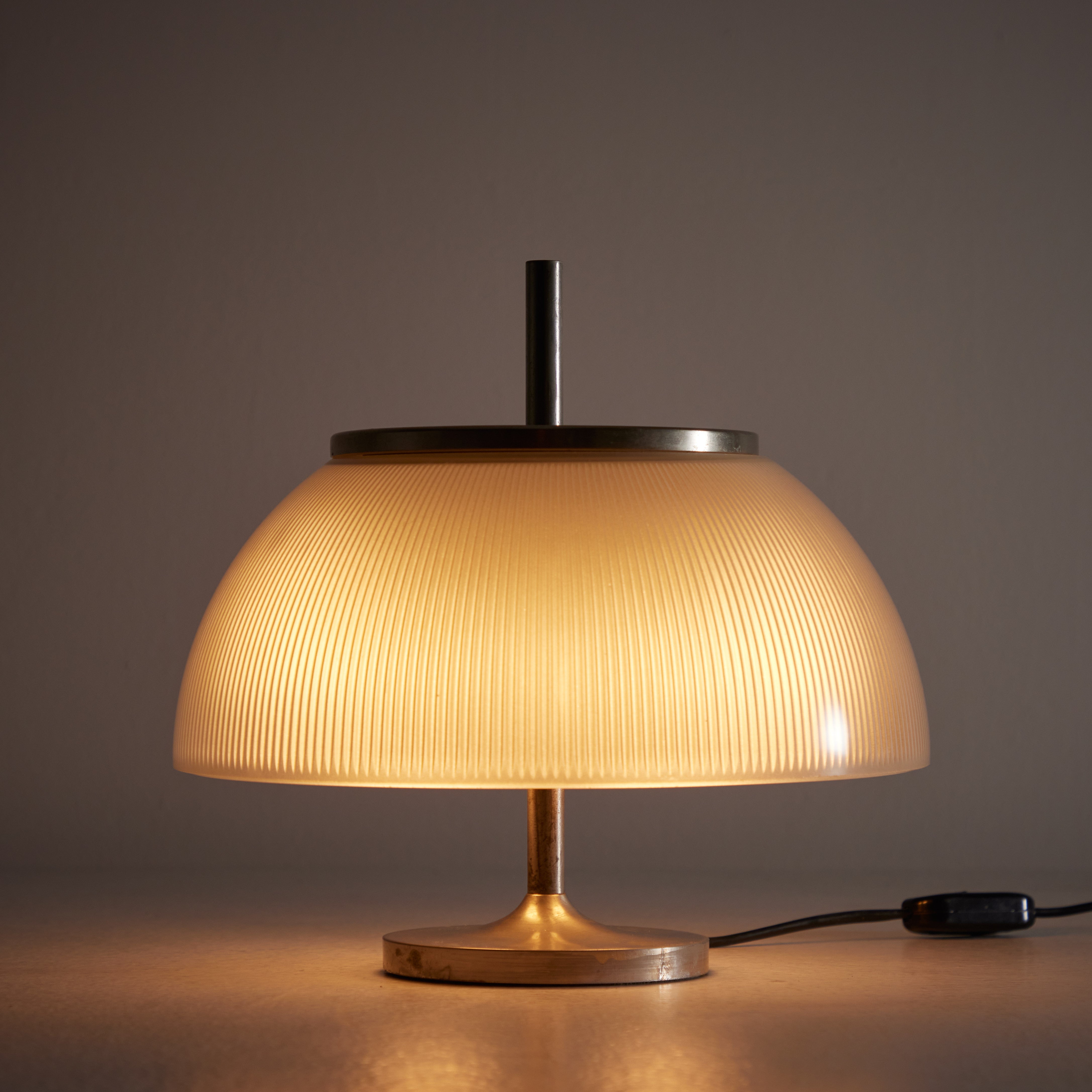 'Alfetta' Table Lamp by Sergio Mazza for Artemide. Designed and manufactured in Italy, in 1966. Petite table lamp with curved nickelplated frame and internally-reeded opaline glass shade. The lamp holds two E14 sockets, adapted for the US. We