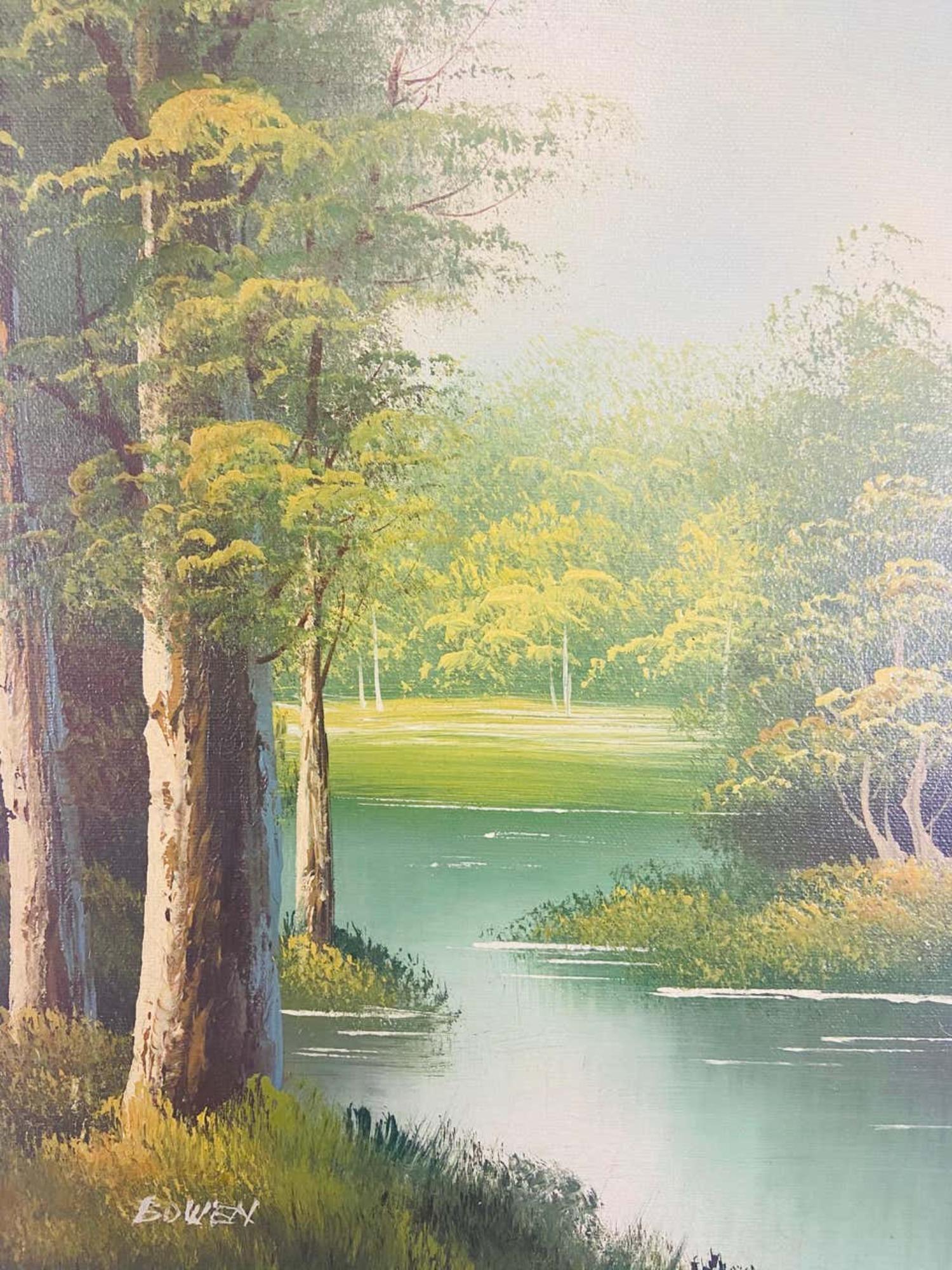 An oil on canvas landscape painting featuring a peaceful scene of a river in the middle of the wood. The painting is made in green color tone. The art work is finely framed in custom handmade wooden frame painted in dark green and gilt color. This