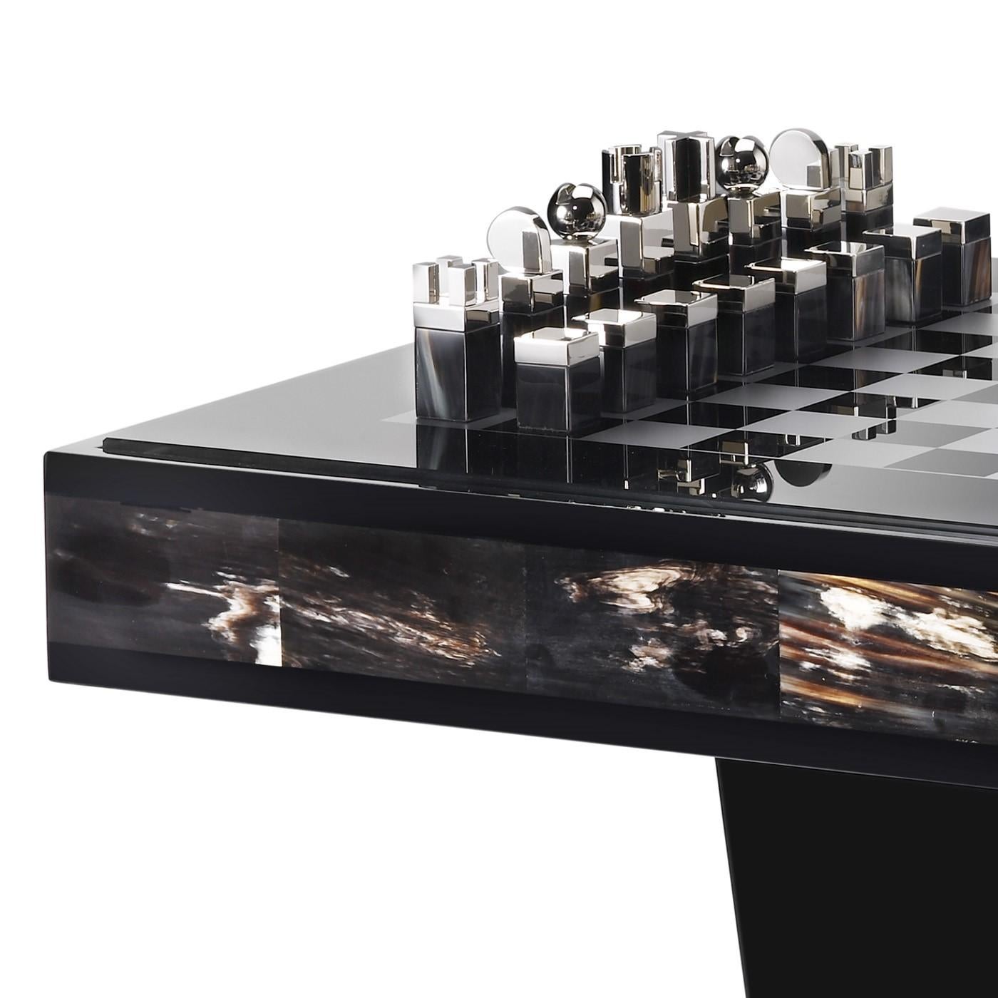 This stunning Alfio Chess Table is crafted in dark horn and black lacquered wood and features a top in smoked tempered glass with a silver chessboard design. The splendid chessboard pieces are made from horn and palladium plated brass. Designed by