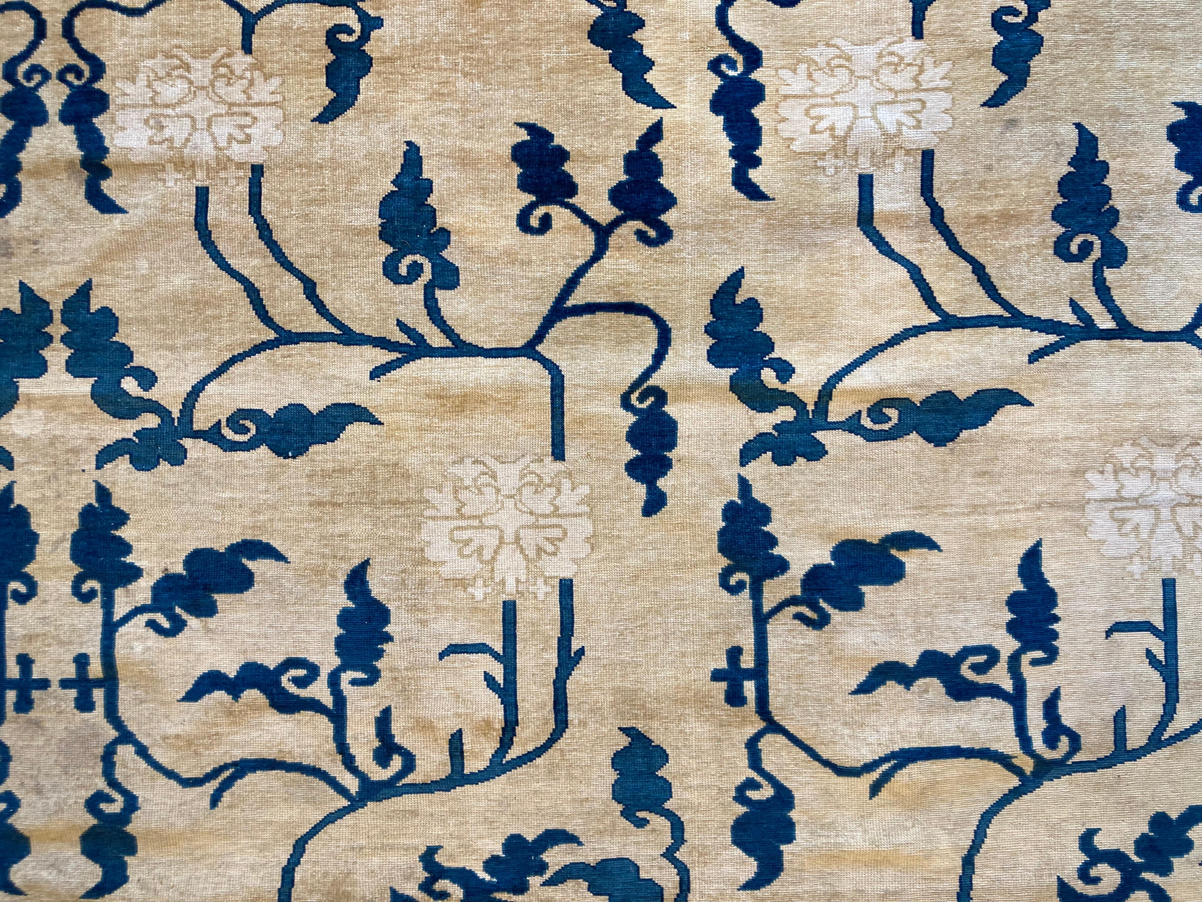 Alfombra china realizada en el siglo XX basada en los cartones de alfombras del XVIII con la misma técnica.
Seine Dekoration basiert auf einer Verkleidung aus Ponias, Rampen und Hörnern in verschiedenen Blautönen, die alle auf einem beigefarbenen