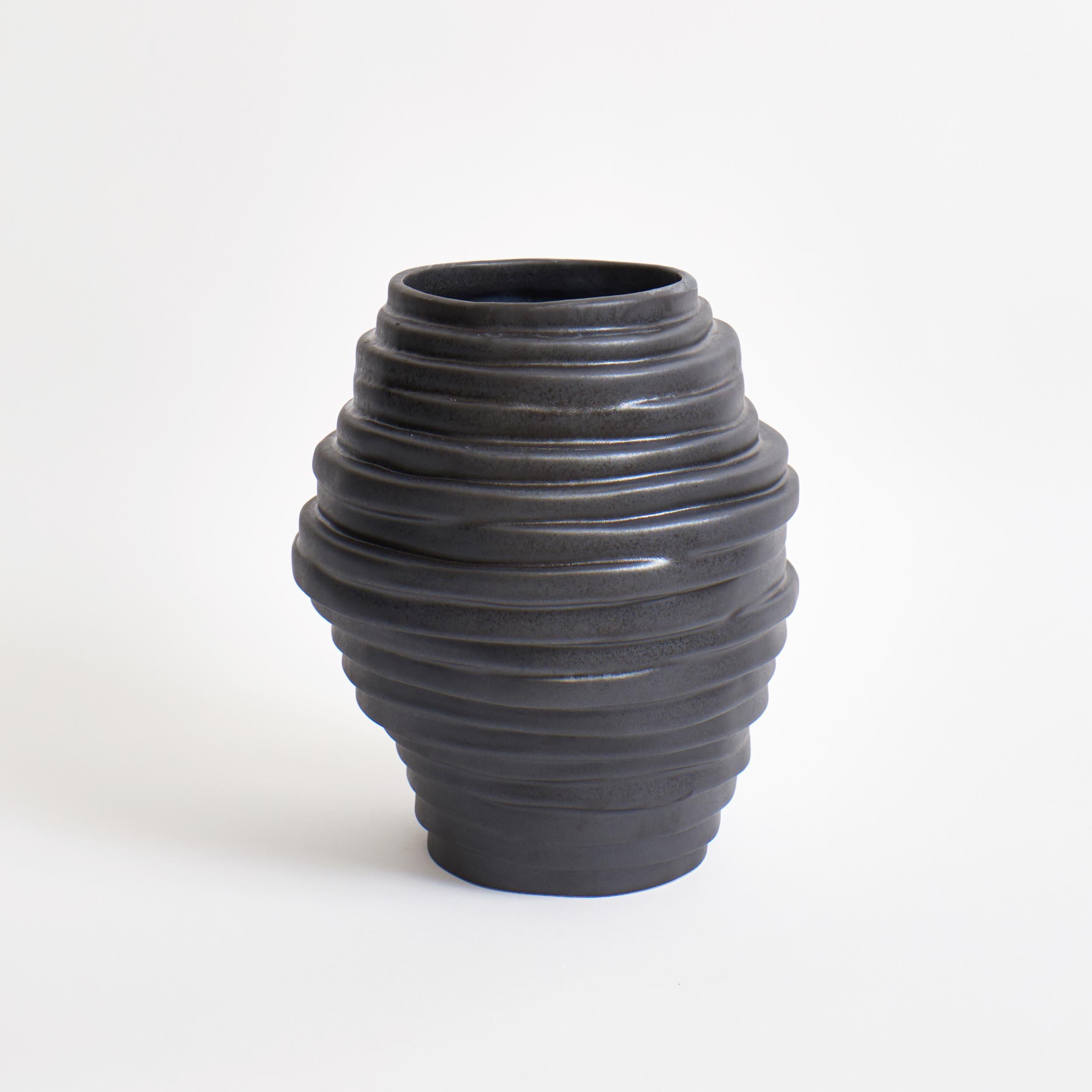 This vase draws inspiration from the Icelandic volcanic rock formations which can be found by Reynisfjara Black Sand Beach. It his sculpted by organically displacing seventeen individual layers. 

This glaze is in matt graphite coloured finish