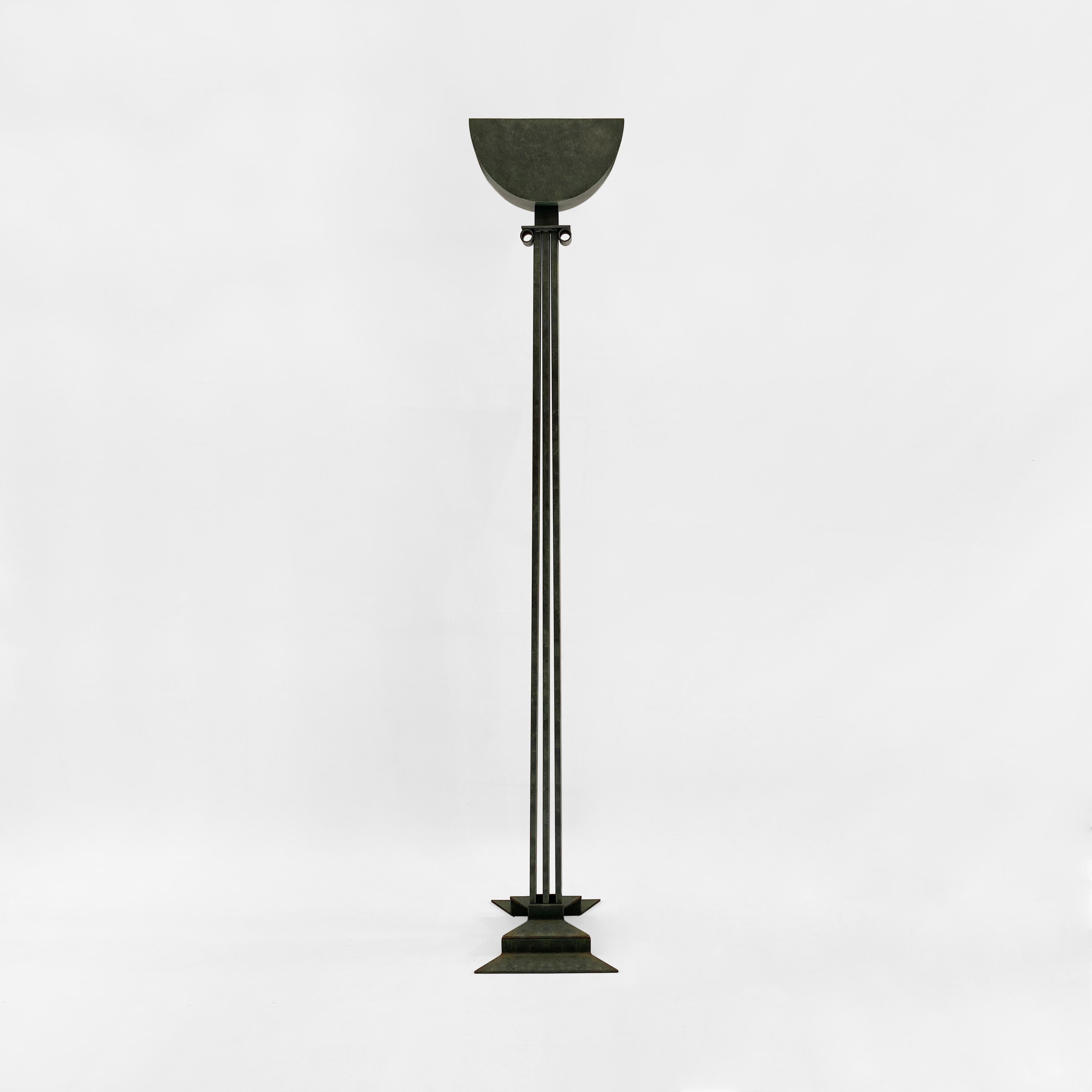 This impressive floor lamp is a playful, post-modern look at neoclassicism. The base is shaped like a bow, and from that protrudes three straight columns, meeting at an ionic head. A half-moon uplighter completes the piece, which is made entirely of