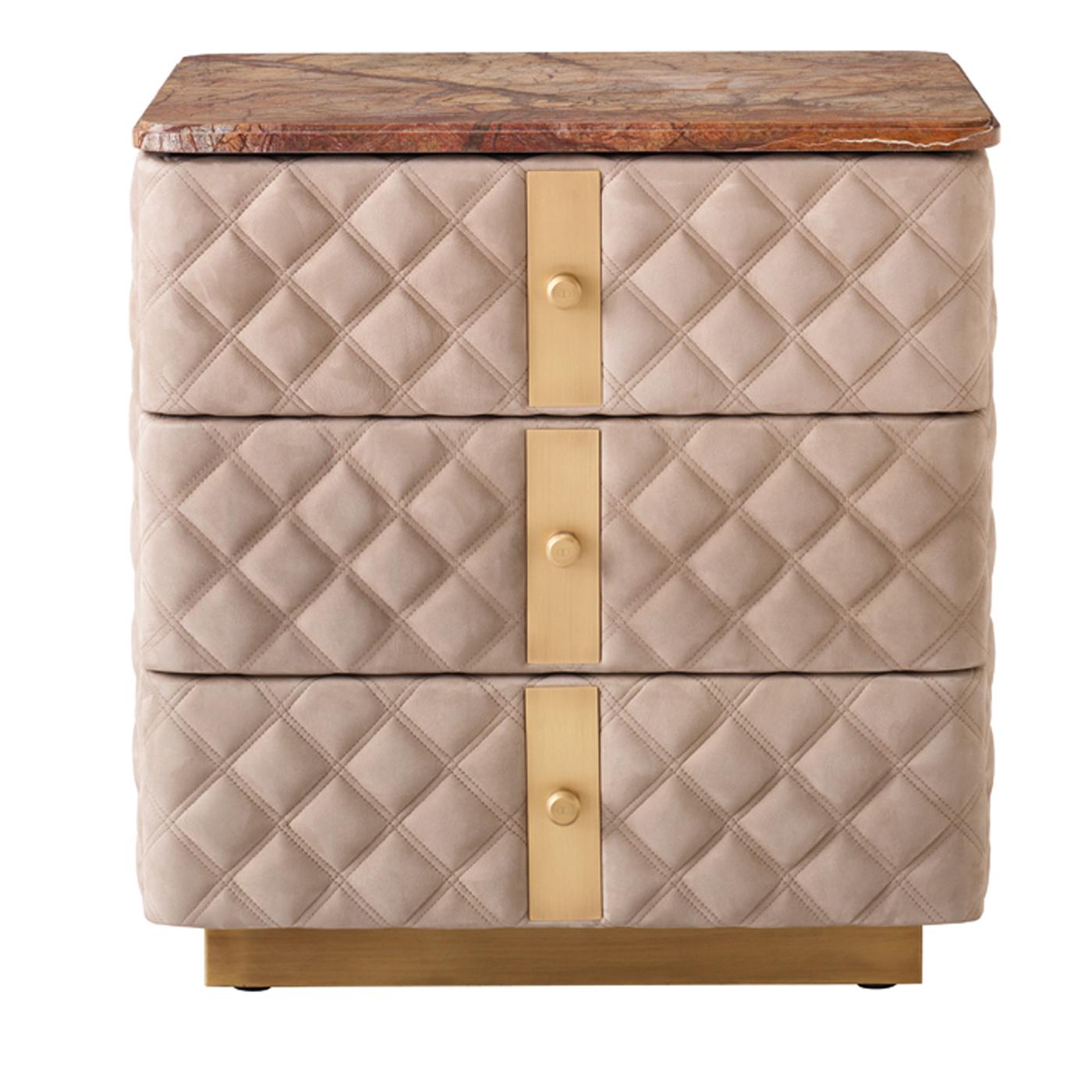 The 3-drawer nightstand features diamond-shaped quilting, inserts in brass finish and logoed buttons. With fully lined drawers on soft metal runners, this exquisite bedroom accessory features a base and handles in brass with a burnished brass