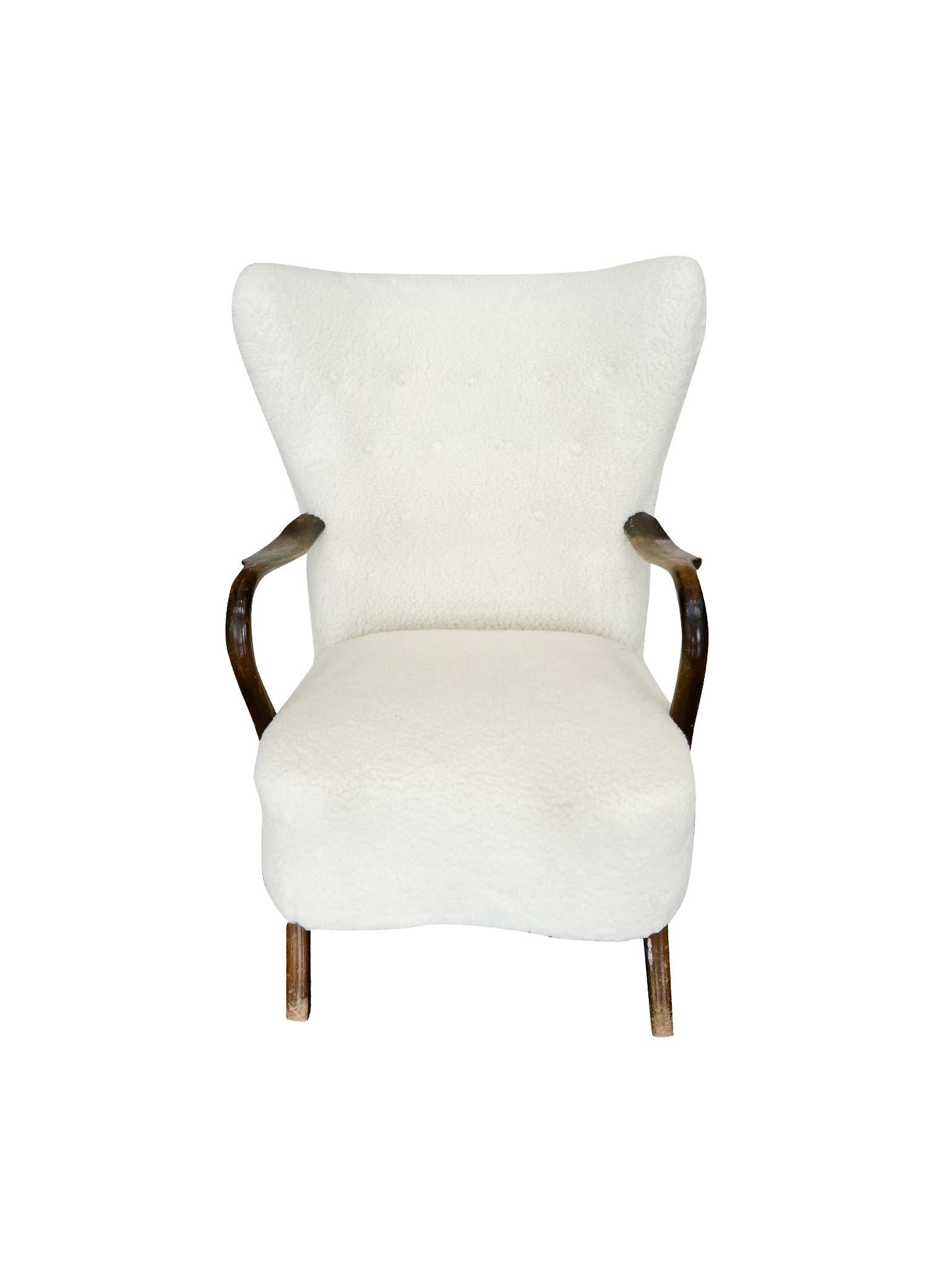 Made in the 1960s, this lounge chair was designed by Alfred Christensen for Slagelse Mobelvaerk. It consists of beech wood with lambswool upholstery. A balance of thin and rounded forms characterize the design, apparent in the curved arms and