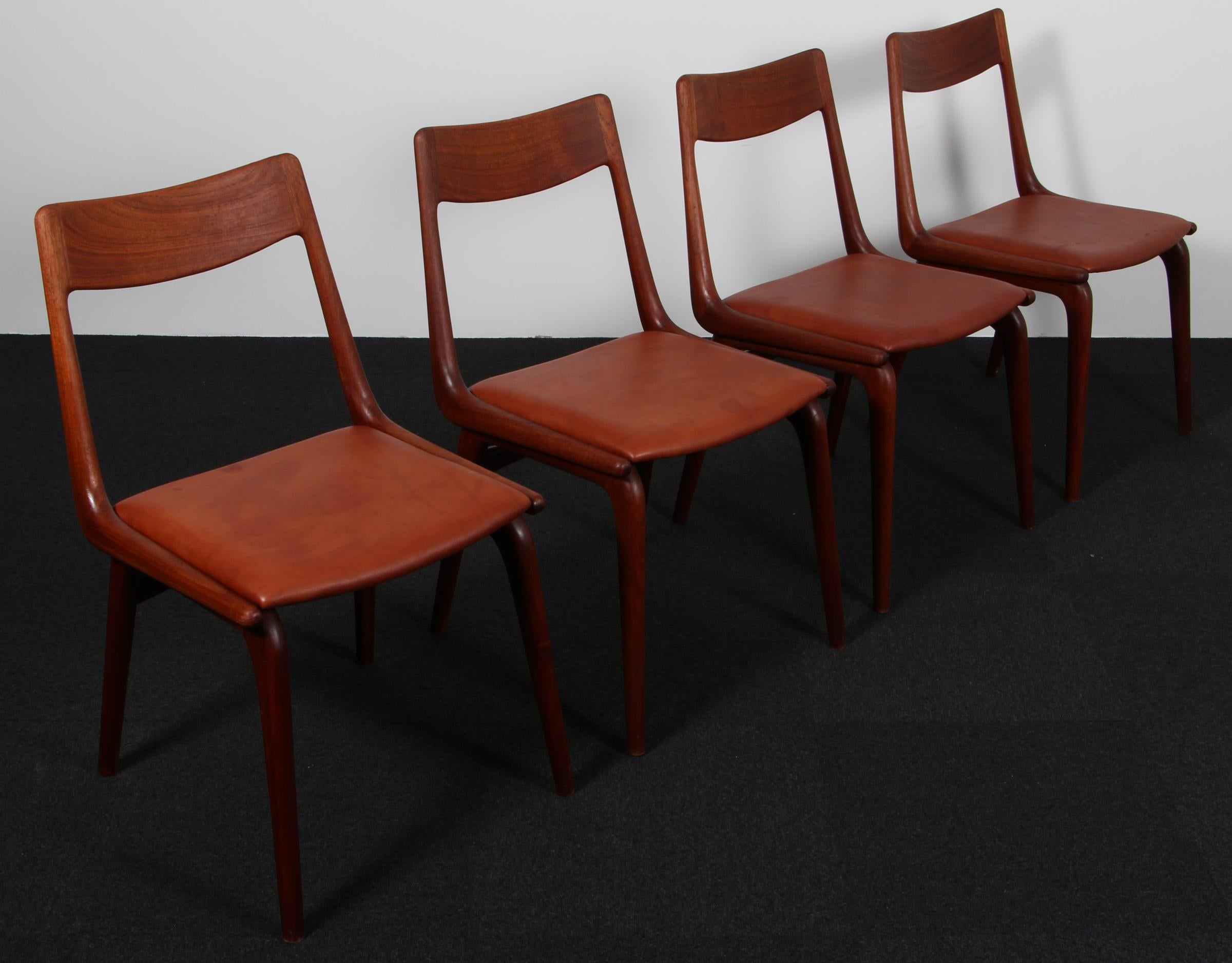 Alfred Christensen dining chairs in teak, new upholstered with cognac smooth aniline leather.

Model Boomerang, made by Slagelse Møbelværk.
 
