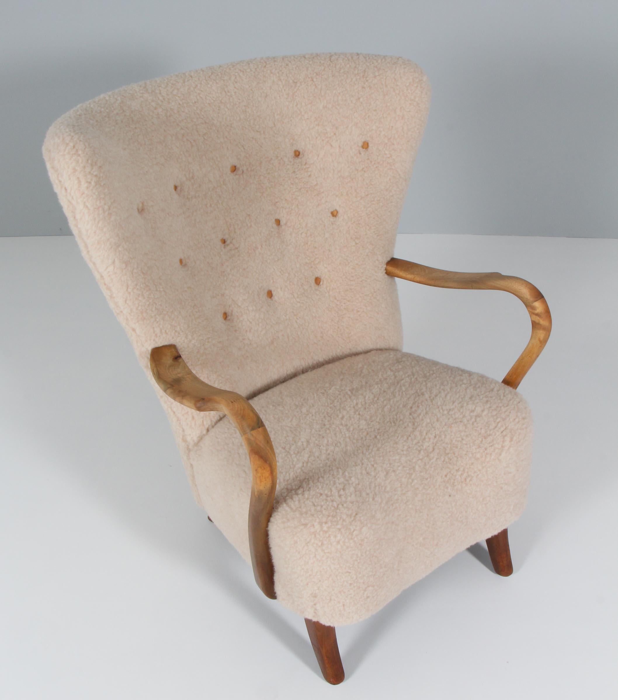 Alfred Christensen lounge chair new upholstered with lamb wool and buttons of leather.

Legs and armrests of nut wood.

Made in the 1940s by Slagelse Møbelværk.

 