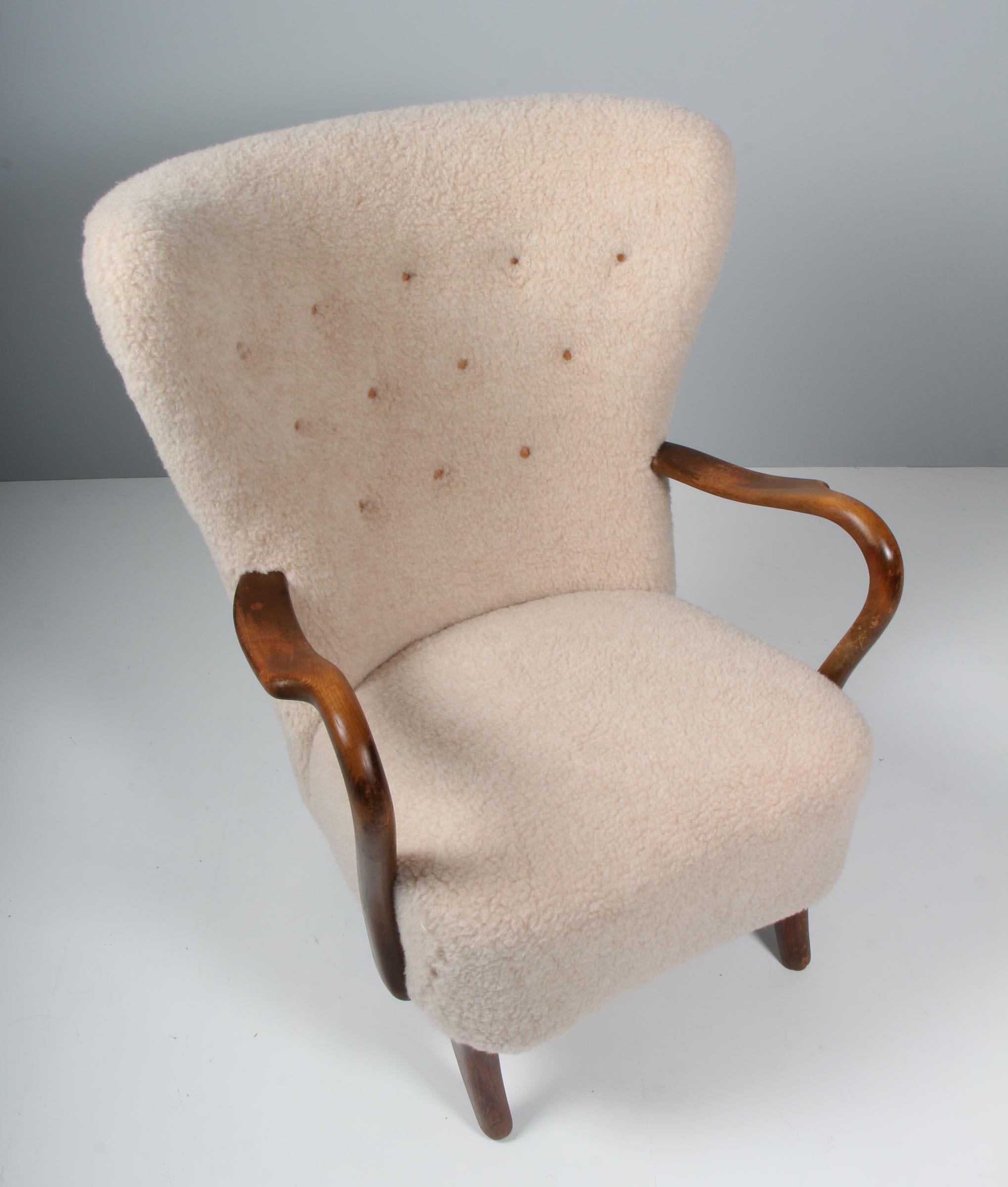 Alfred Christensen lounge chair new upholstered with lamb wool and buttons of leather.

Legs and armrests of stained beech.

Made in the 1940s by Slagelse Møbelværk.

 