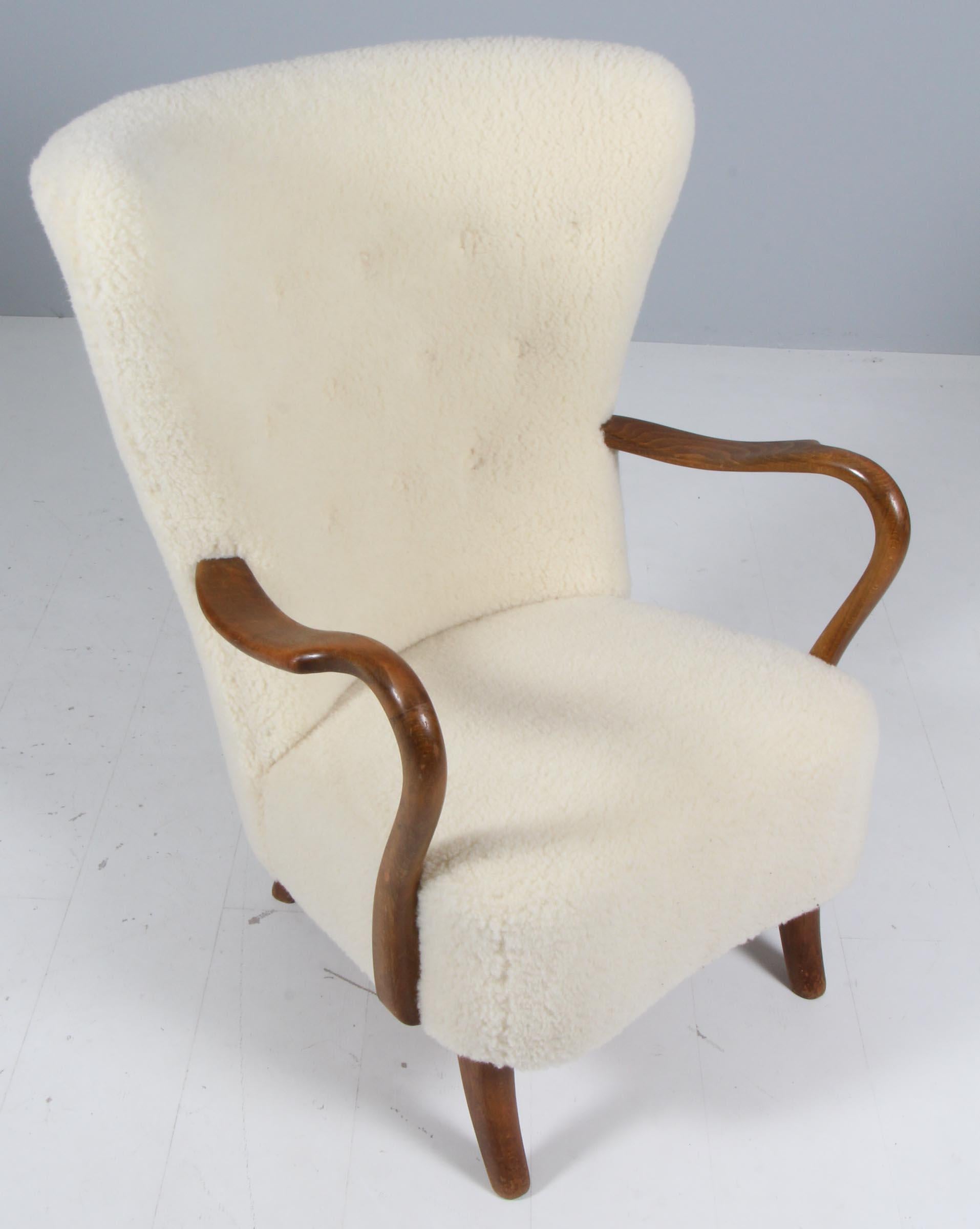 Alfred Christensen lounge chair new upholstered with lamb wool.

Legs and armrests of stained beech.

Made in the 1940s by Slagelse Møbelværk.

 