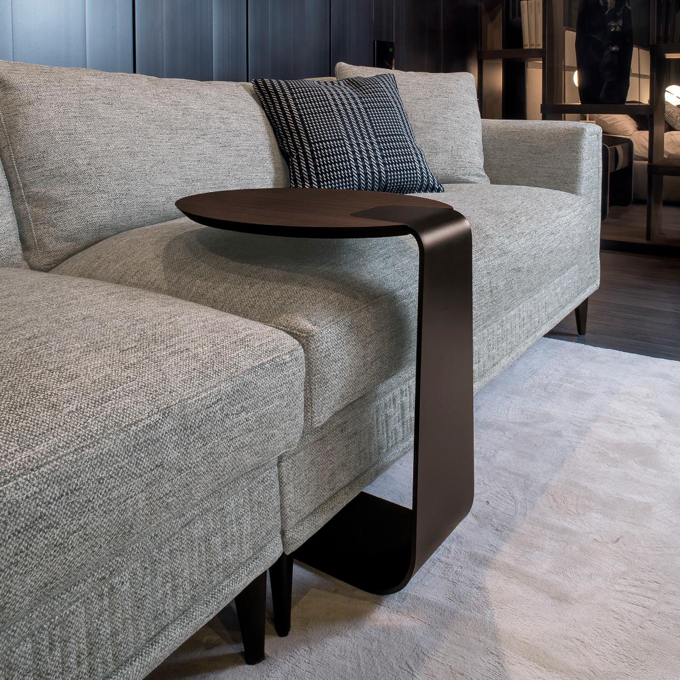 The quintessential expression of minimalist design, this astonishing coffee table boasts an iconic charm in its pure and simple shape. Composed of a curved and painted metal base supporting a round top in smoked eucalyptus MDF from one side, it will