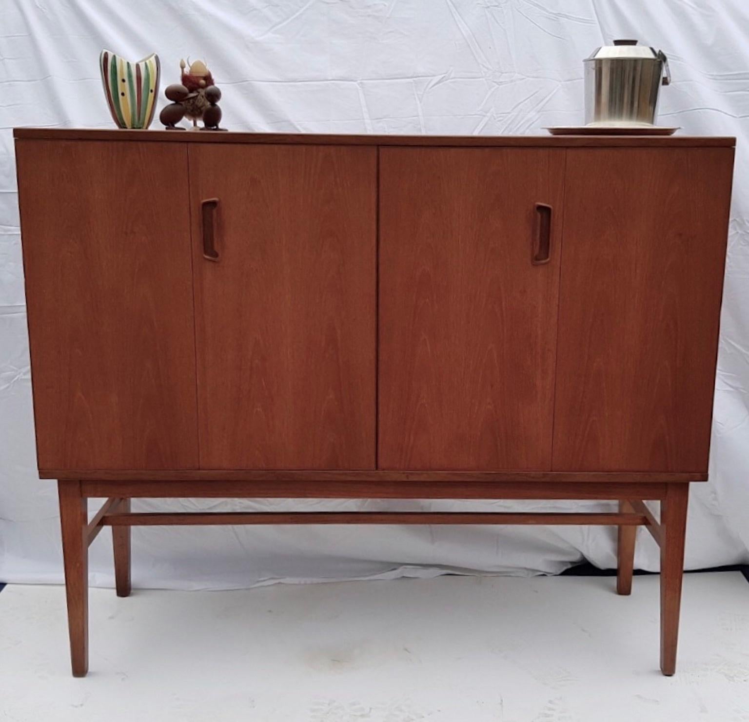 Alfred Cox for heals Danish design teak highboard drinks cabinet / sideboard, English, 1950s

Spectacular teak highboard /drinks cabinet designed by Alfred Cox for Handicraft and retailed through Heals, a hugely versatile cabinet with bi-fold doors,