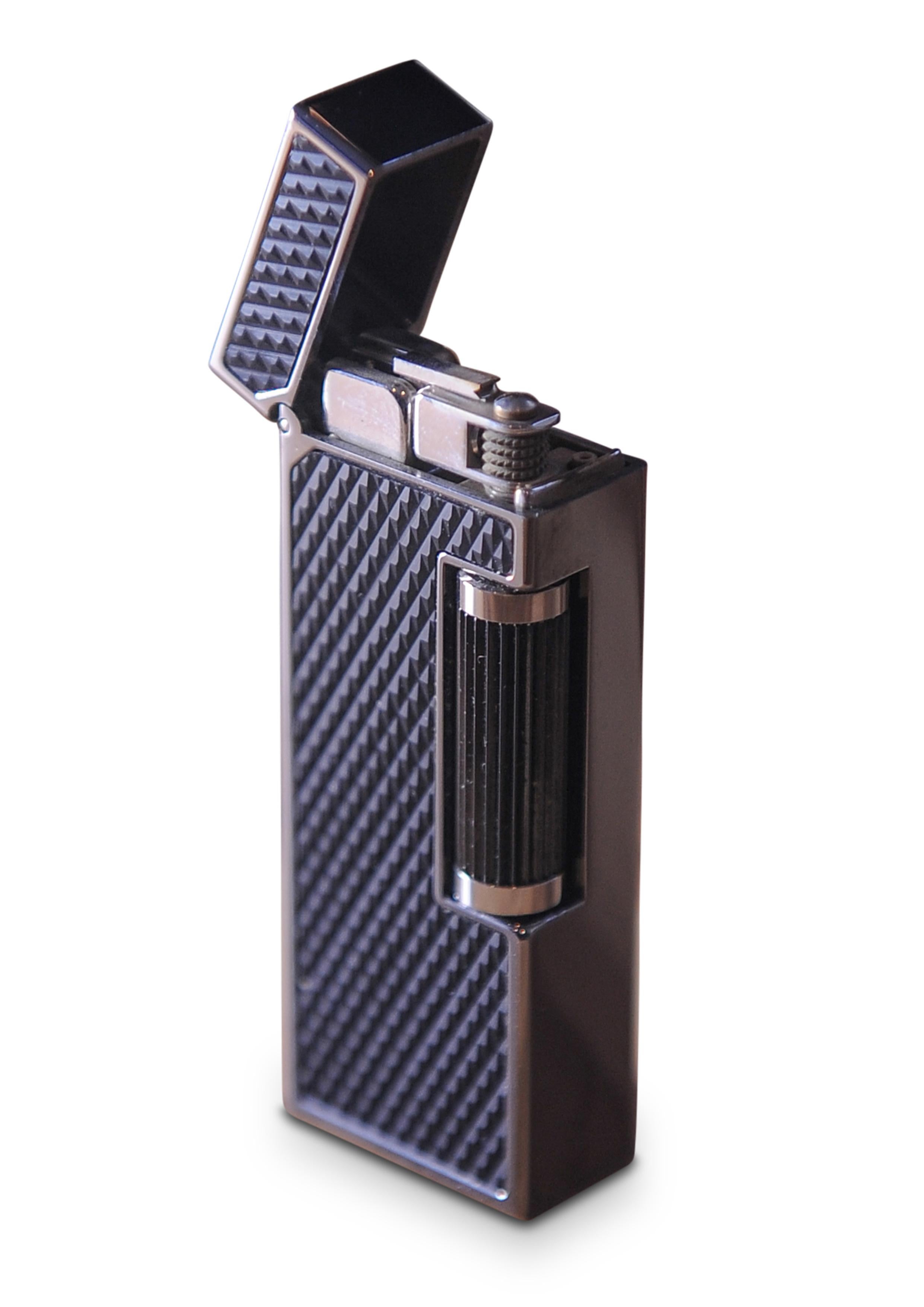 Alfred Dunhill Carbon Fibre Palladium Plated Rollagas Cigarette Lighter With Original Box, Papers & Sleeve Near Mint 
Black Resin D Pattern 

Stamped Dunhill & Swiss Made on Lighter Base


The Rollagas lighter is a dunhill classic, featuring