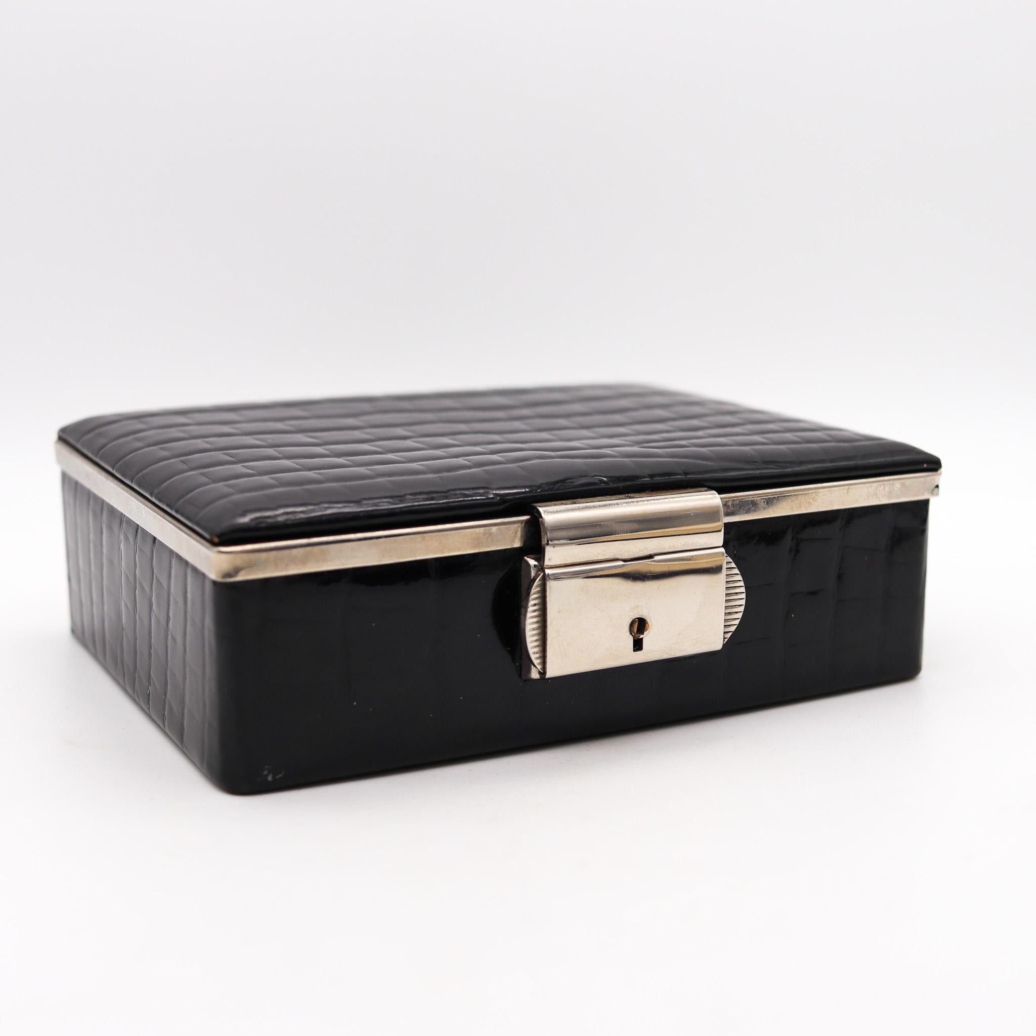 Desk box designed by Dunhill.

Beautiful decorative vintage desk box, created in Germany for Alfred Dunhill, back in the 1990. It was made up in shiny black leather with a discrete frame in chromed steel. The inside is lined up with gray fabric.