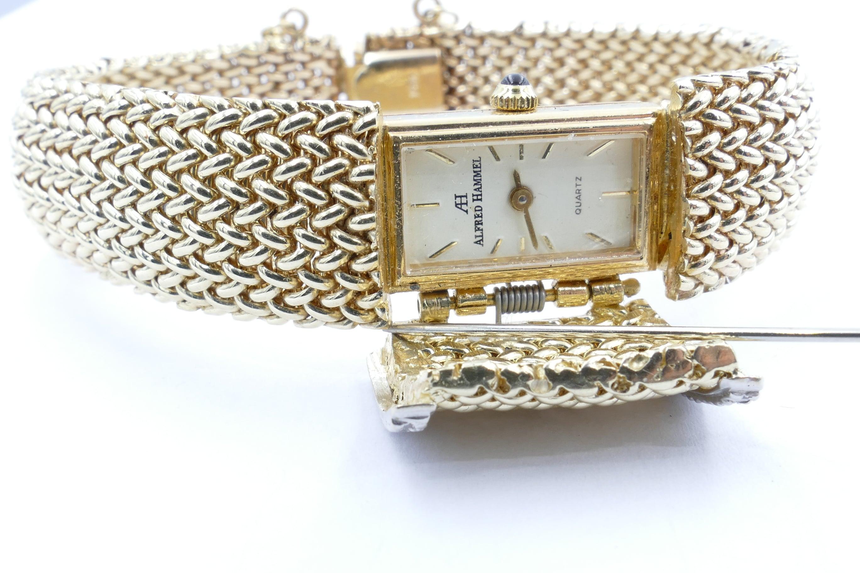 Designer & numbered  Alfred Hammel Bracelet Watch 029/100 is made from solid 18ct  yellow Gold with Quartz movement.
It features a concealed rectangular near white Dial with baton numerals.
The Integral Bracelet band has 14 round brilliant cut