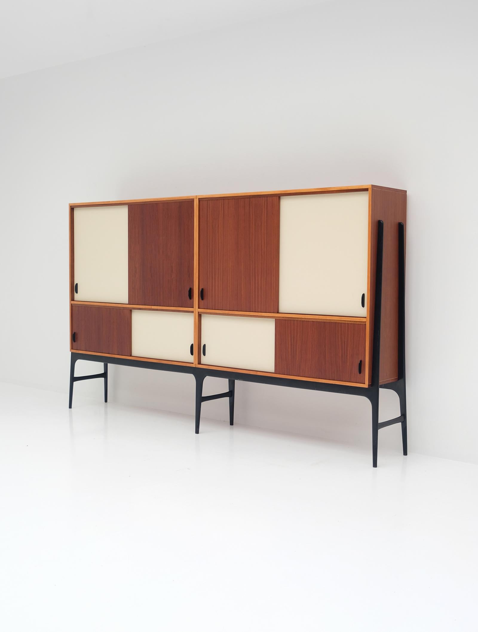 This exclusive sideboard was designed by Alfred Hendrickx for Belform in the late 50s during EXPO 58. The bigger part consists out of 2 pieces, the black lacquered base is made out of one piece. Inside there is a lot of storage space due the many