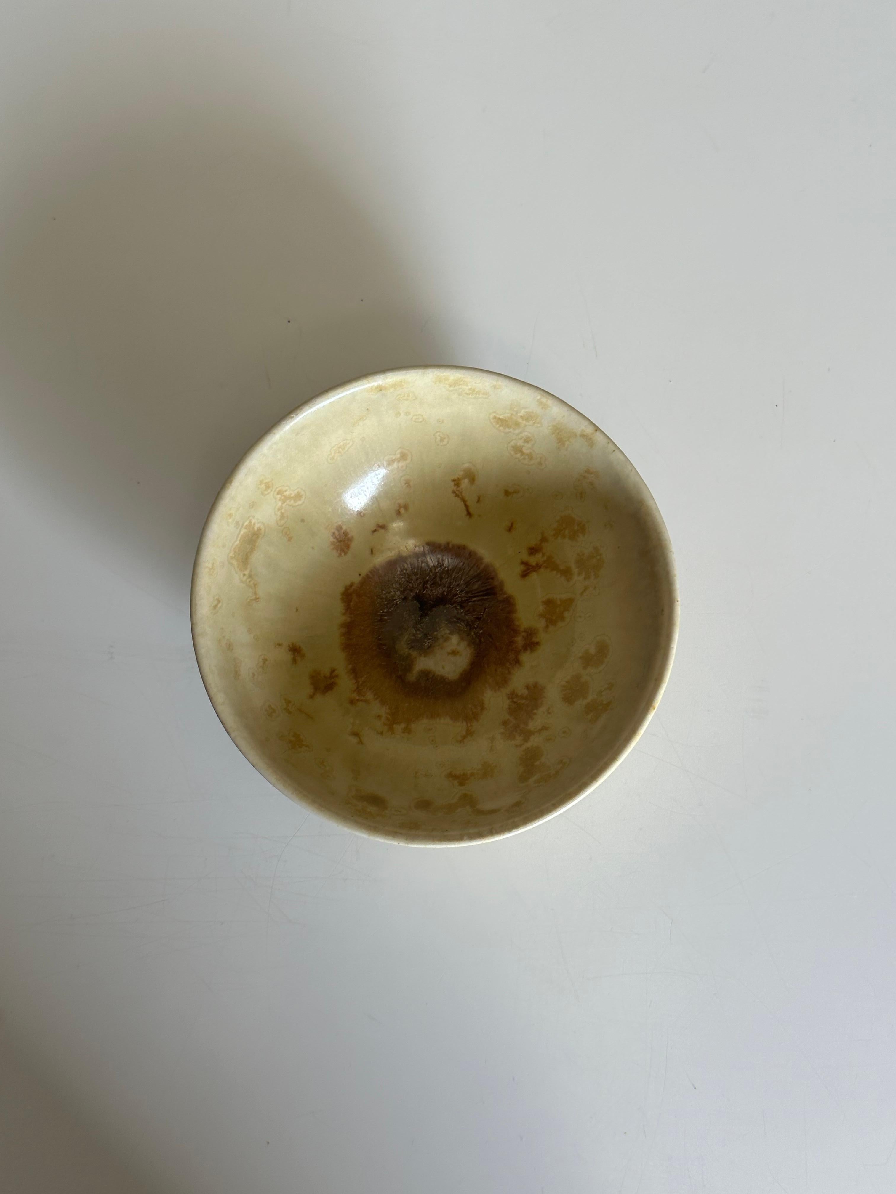 Una piccola ciotola decorativa disegnata da Alfred Johansson per Höganäs Keramik. Design molto particolare con smalto giallo chiaro e spruzzi di colore marrone. 

Altri importanti designer del periodo sono Gunnar Nylund, Carl-Harry Stålhane, ecc.