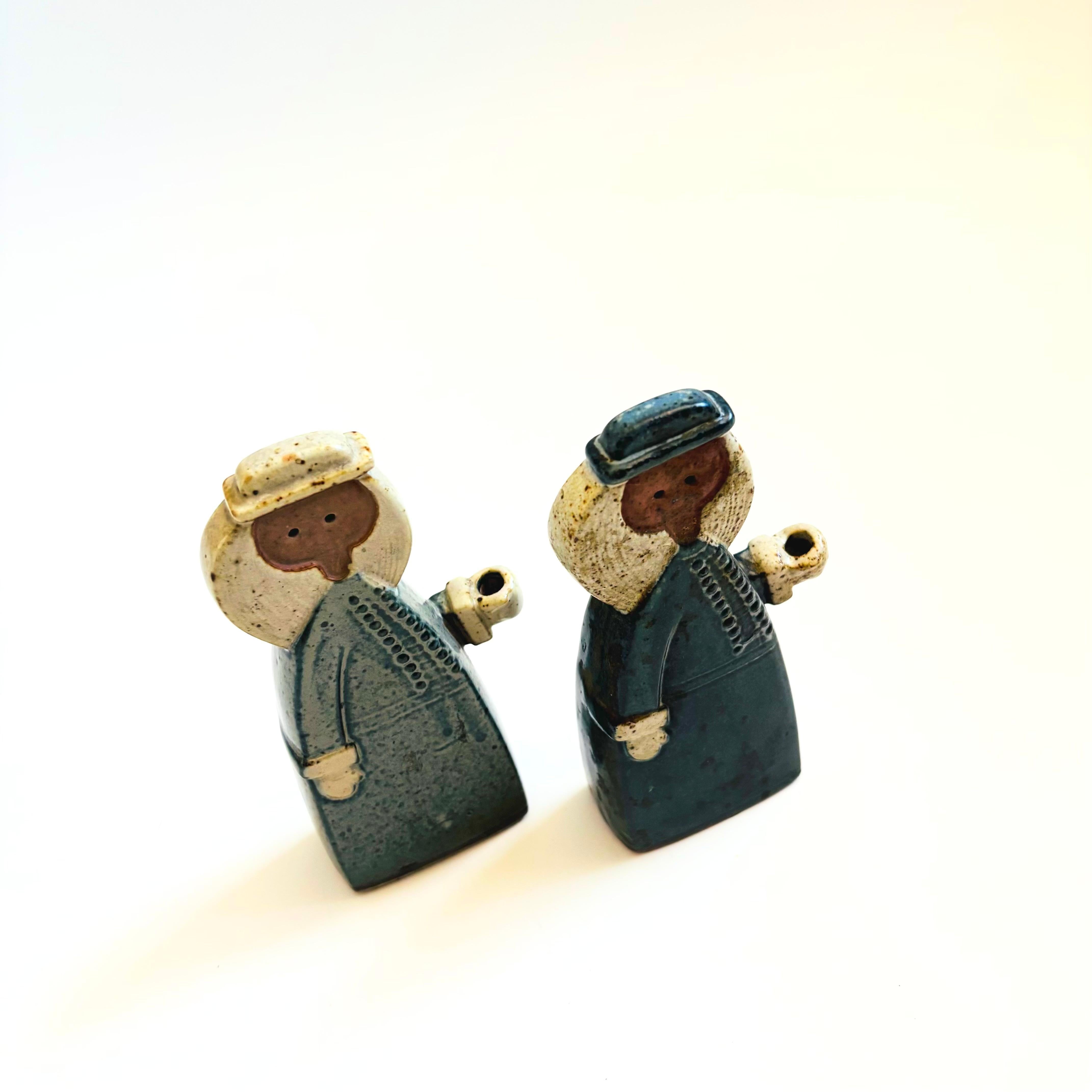 A set of 2 mid century pottery candle holder designed by Alfred Knobler, made in Japan. Each in the shape of woman. Great Scandinavian style to the design with lovely speckled blue, gray, and brown glazes. Meant to hold tiny taper candles.

