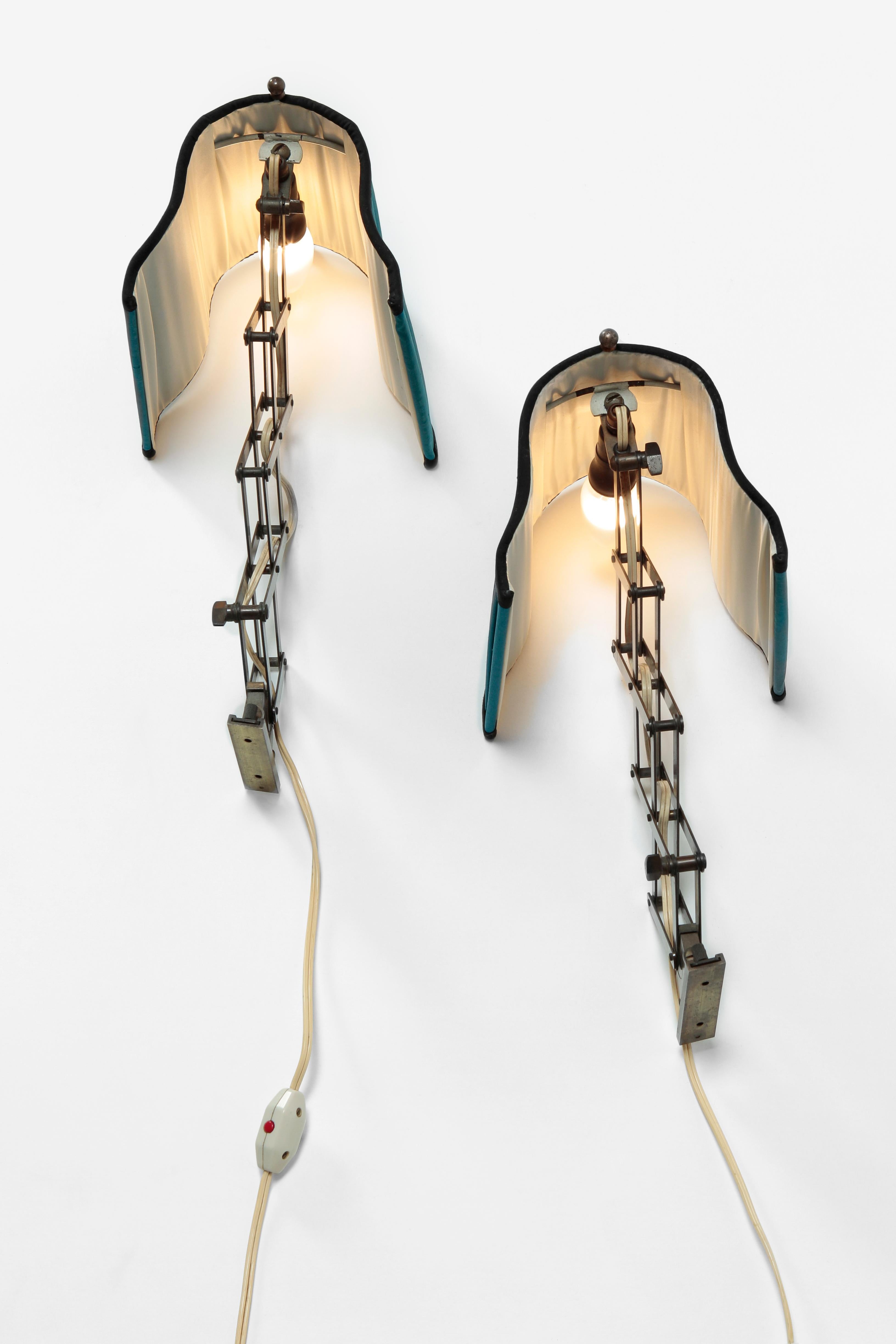 Alfred Müller wall lights manufactured by Amba in the 1940s in Switzerland, Basel. High quality scissor lamps with original cotton lamp shades. The edging on the upper and lower frame was renewed. The length is adjustable from 18 cm to 53 cm.