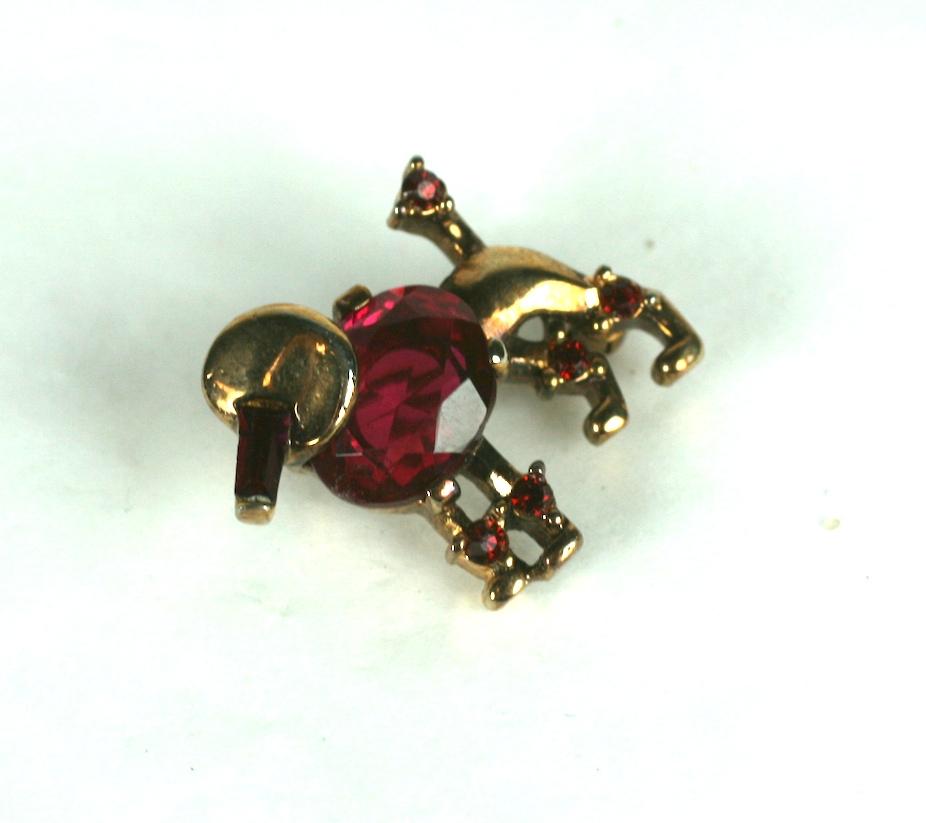 Alfred Philippe for Trifari collectible miniature poodle brooch in gold plated base metal, ruby rhinestone baguette and faux rubies rounds.
Signed Trifari with Crown, Pat Pend.  Designer A Philippe, dated 1949 
Excellent condition. Length 5/8