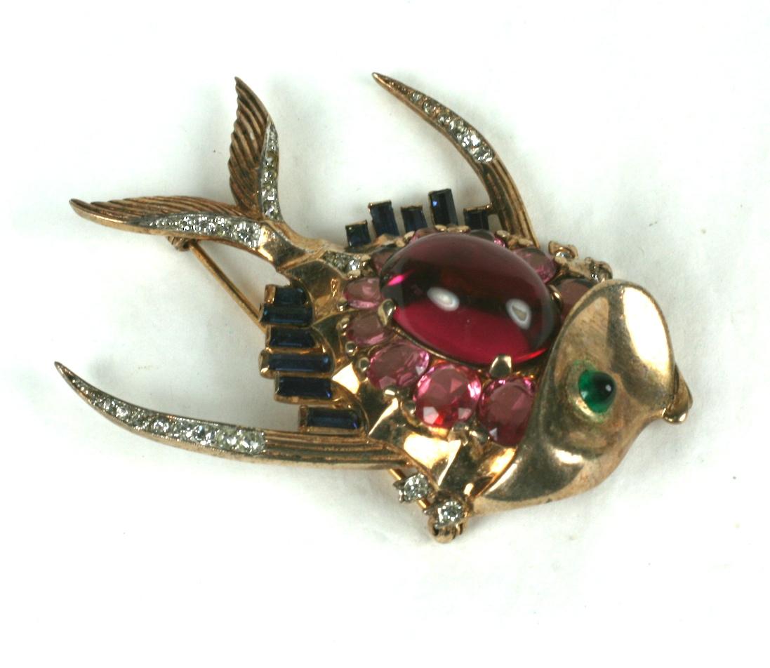 Alfred Phillippe for Trifari Retro style angel fish brooch of rose gold plate sterling silver. Set with a large oval cabocheon faux ruby surrounded by oval faux pink and citrines stones. 
Emerald bullet cabochon eye and rectangular sapphire baguette