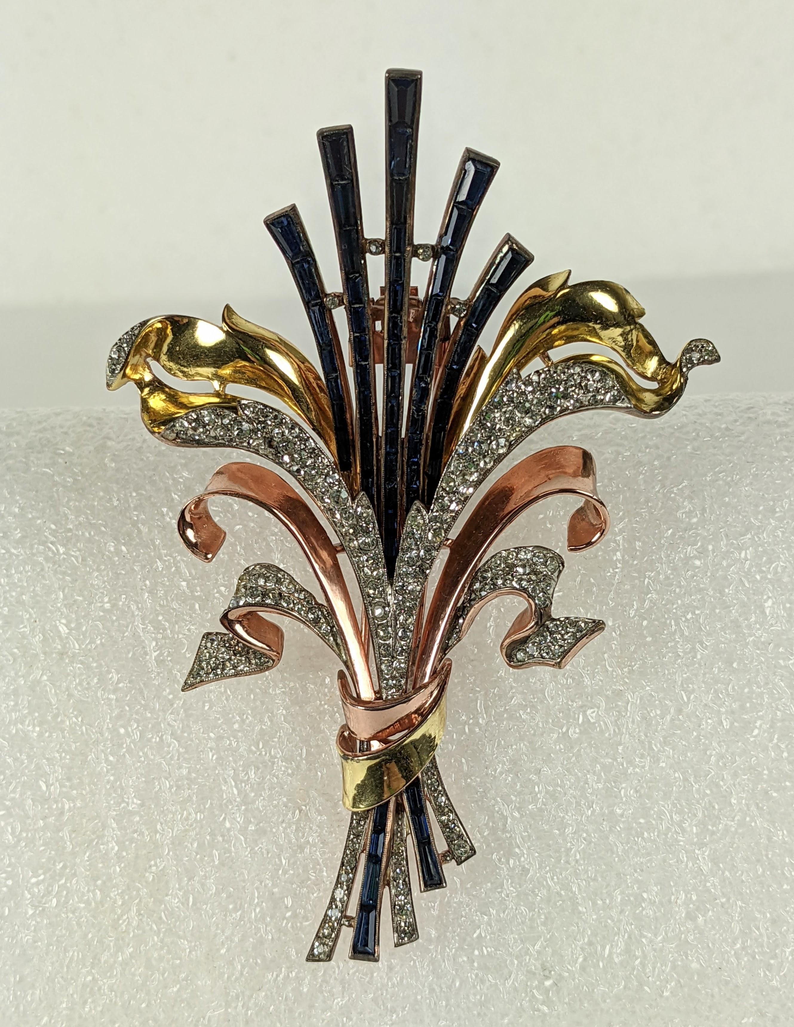 Important Alfred Philippe for Trifari Retro stylized lily flower clip brooch. Of sapphire pave keystone baguettes, set in rhodium base metal with two color rose and yellow gold plate. Unfurling double leaf swirls are trimmed with crystal rhinestone