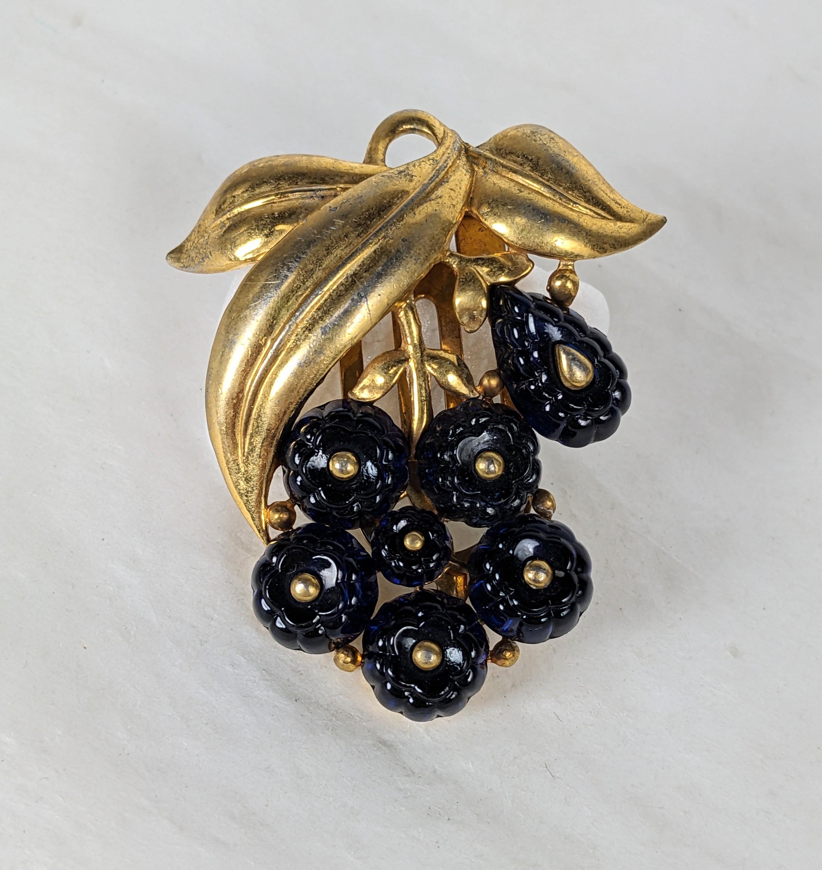 Alfred Philippe for Trifari faux sapphire fruit salad berry cluster dress clip. Of gold plated base metal unfurling  leaf motifs with jelly mold fruit salad glass cabocheons. Marked: Trifari with Crown, About 1938. 
L 2.25