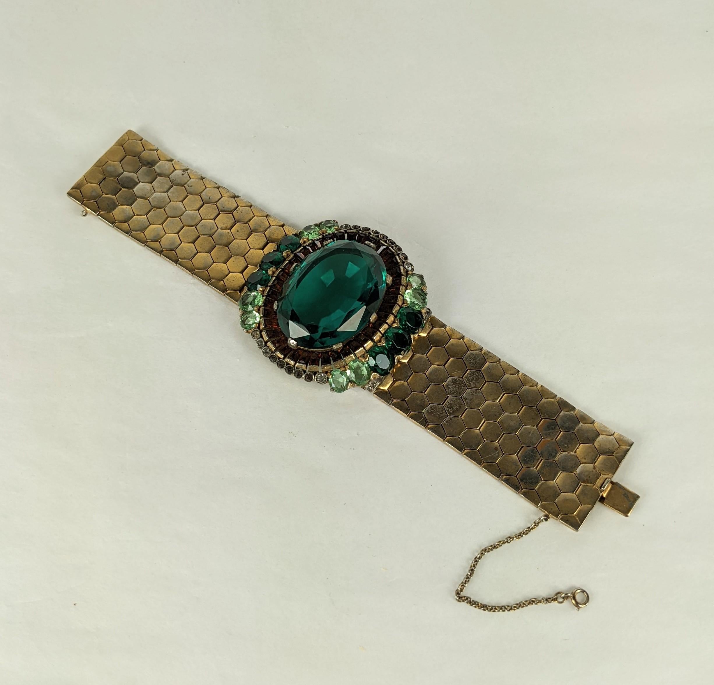 Important Alfred Phillipe Trifari Rare Retro Bracelet from the late 1930's. Oval pastes in emerald and peridot surround a large faux emerald surrounded by topaz baguettes. This central motif is set on a substantial gilt flexible track band. Signed