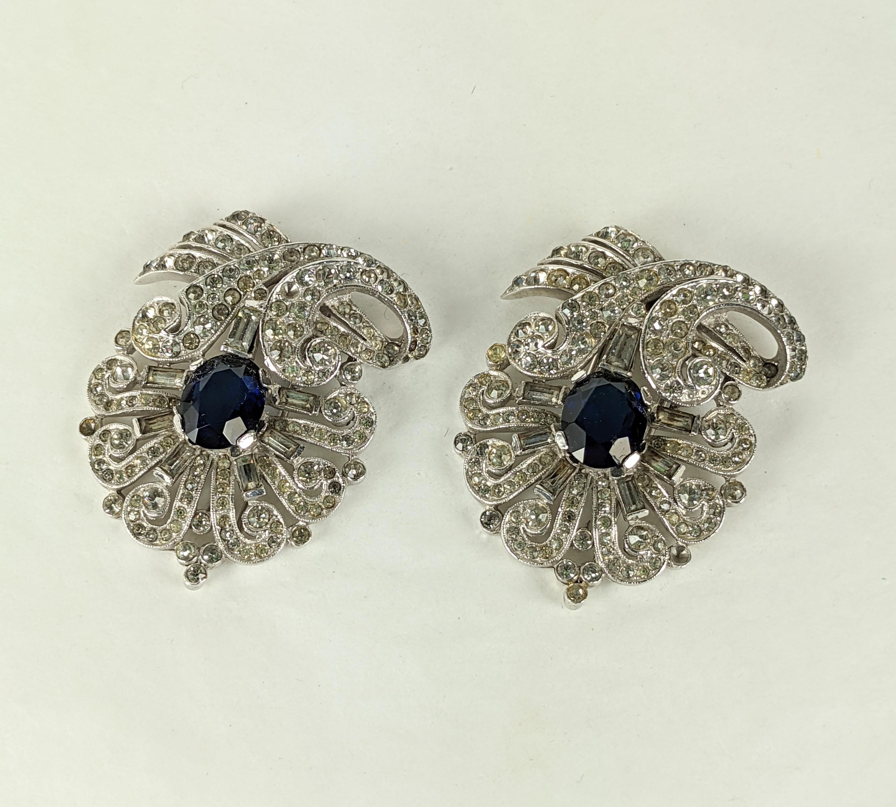 Alfred Philippe for Trifari Art Deco pave and faux sapphire matched pair of dress clips in rhodium plated base metal with crystal rhinestone pave, and faux sapphire oval faceted stones. Marked: Trifari with Crown on the clips, Excellent Condition.
L