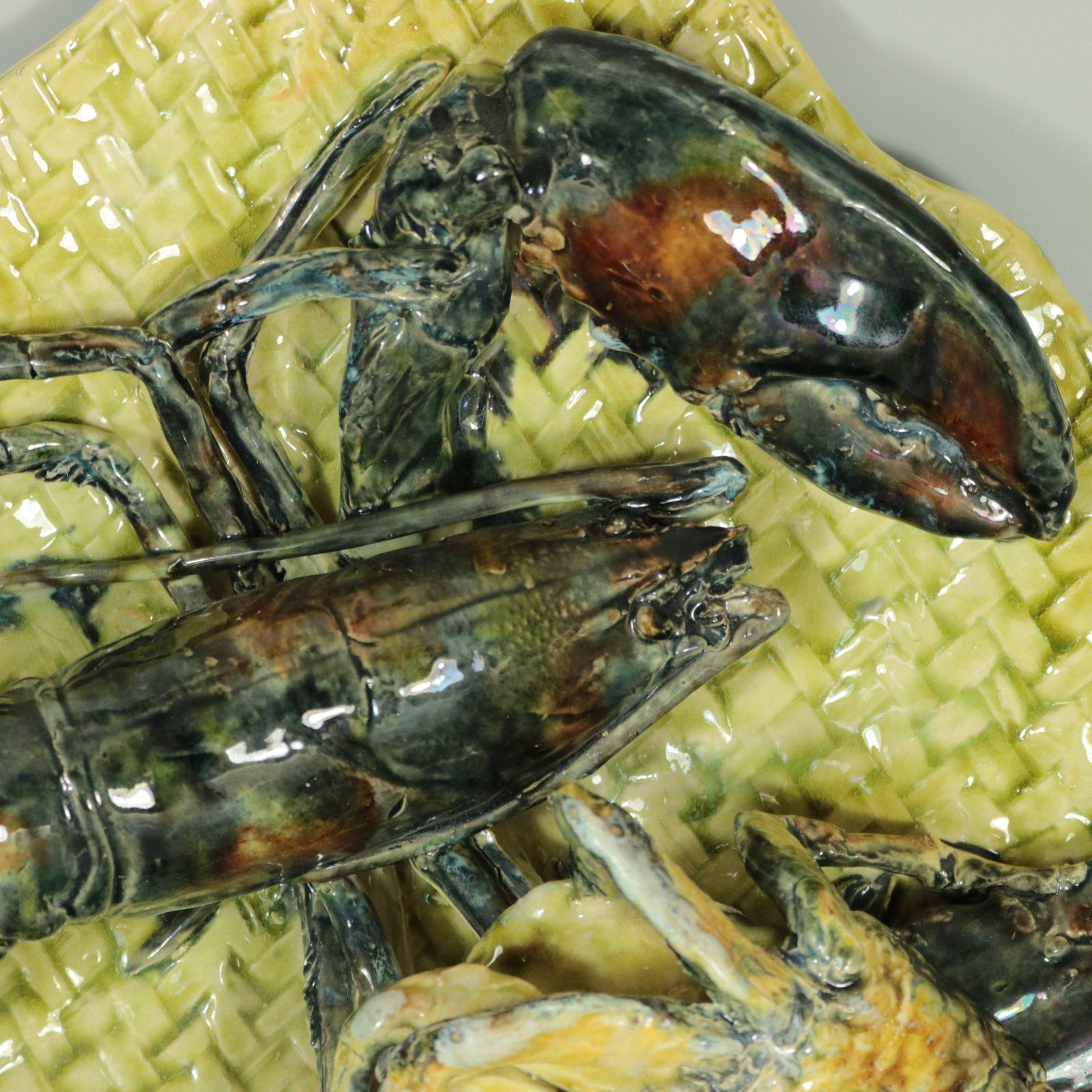 Pochette murale en majolique de Palissy d'Alfred Renoleau, représentant un homard et un crabe sur un fond de vannerie. Coloration : jaune, gris, brun, sont prédominants. La pièce porte les marques du fabricant de la poterie Alfred Renoleau.